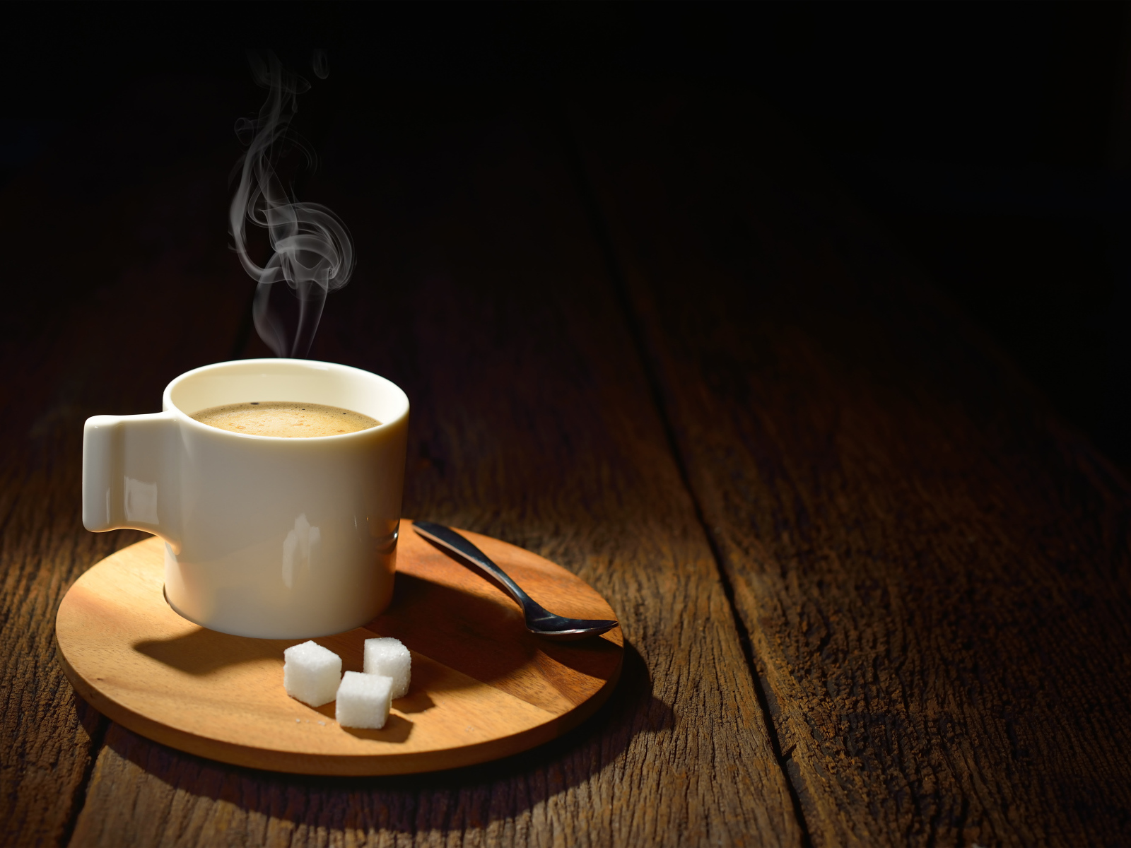 Чашка горячего кофе на столе с сахаром