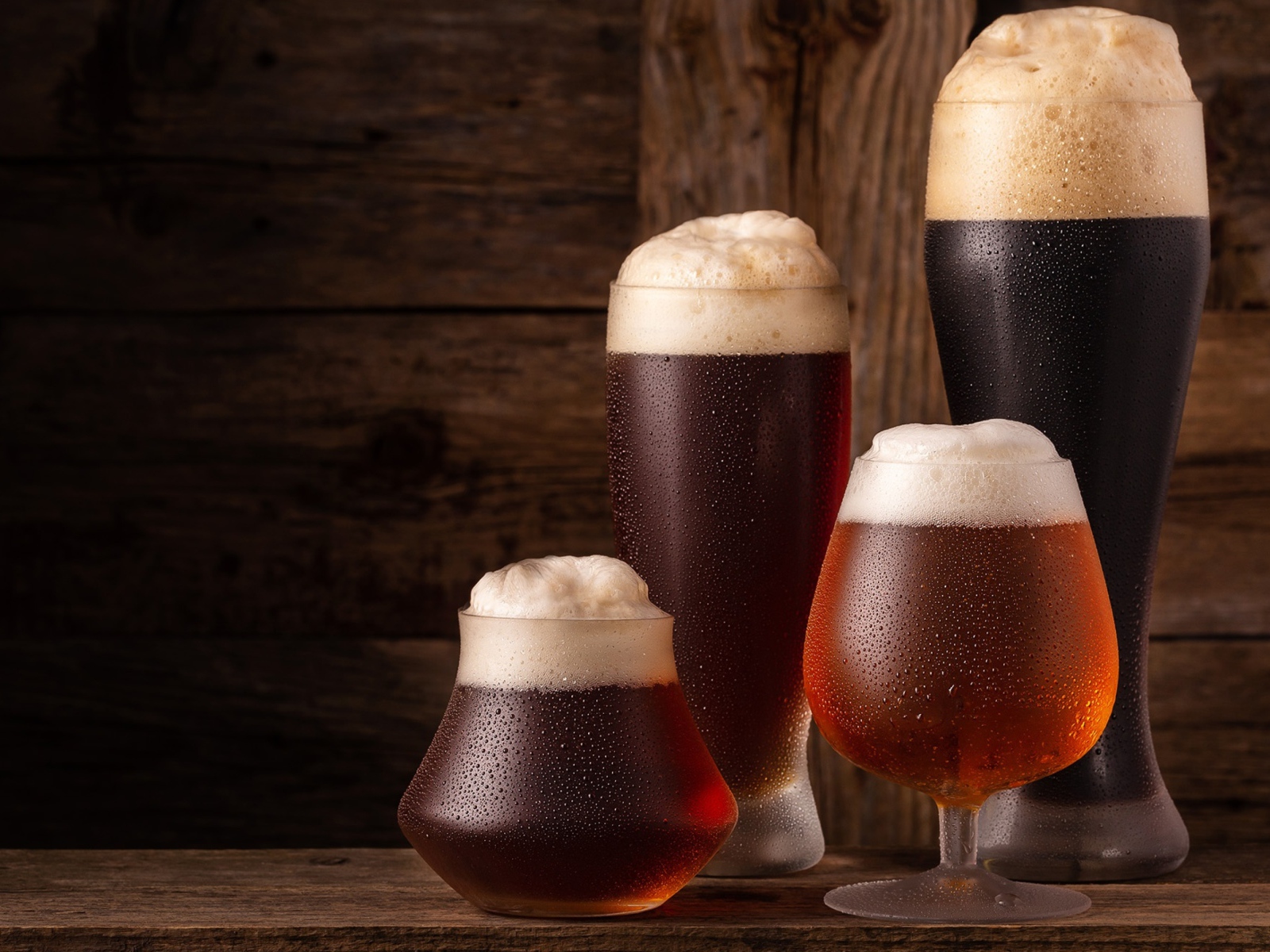 Много бокалов холодного пенного пива на столе 