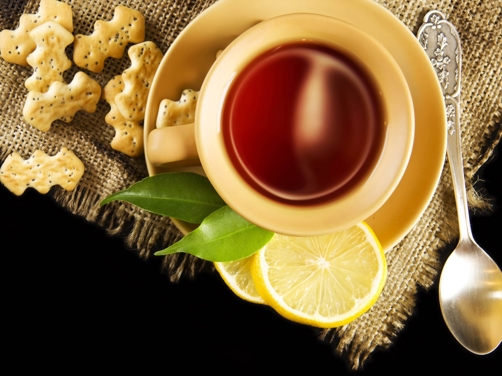 Чай на столе с печеньем и кусочками лимона