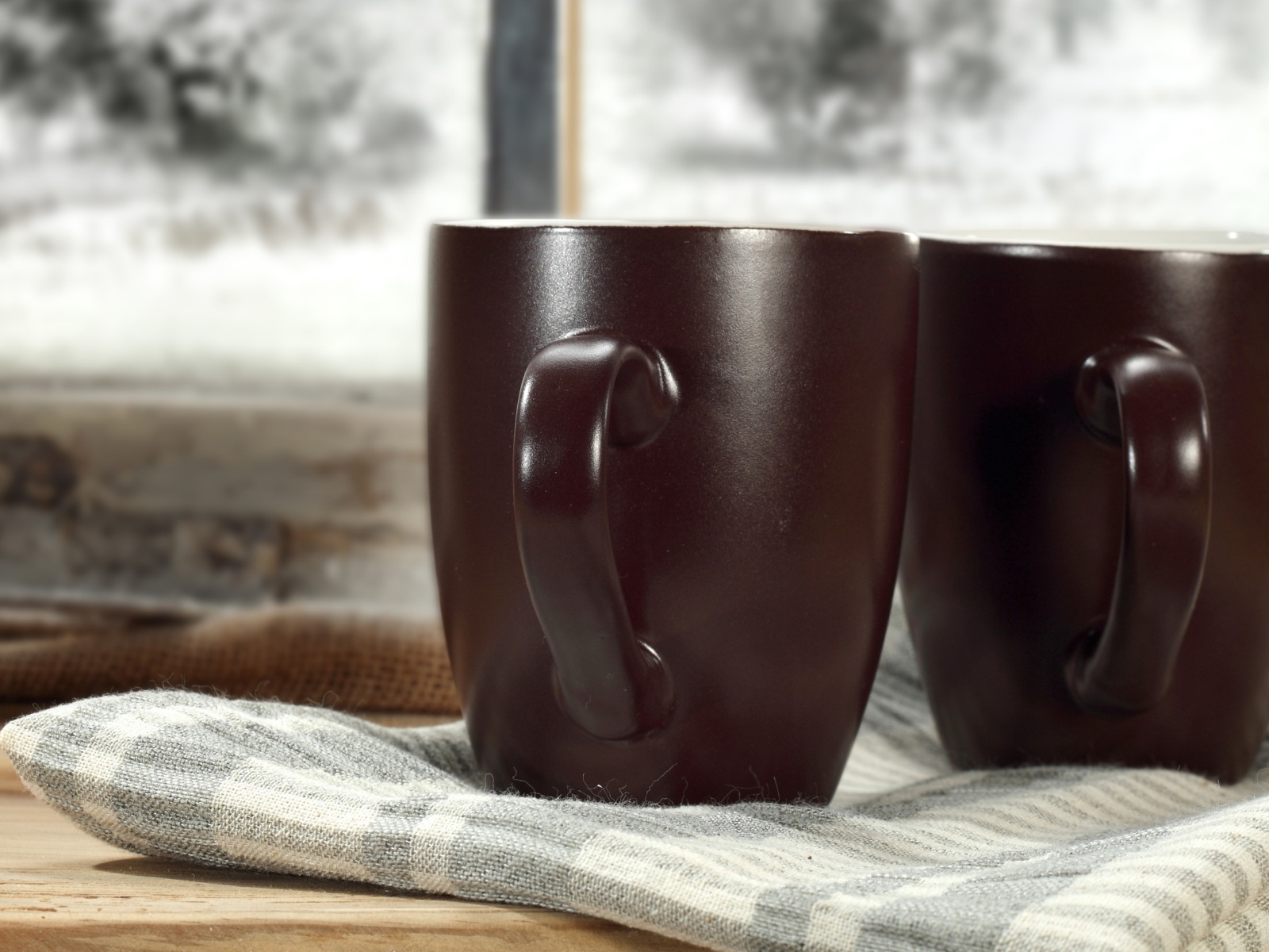 Две коричневые чашки кофе на столе с шарфом