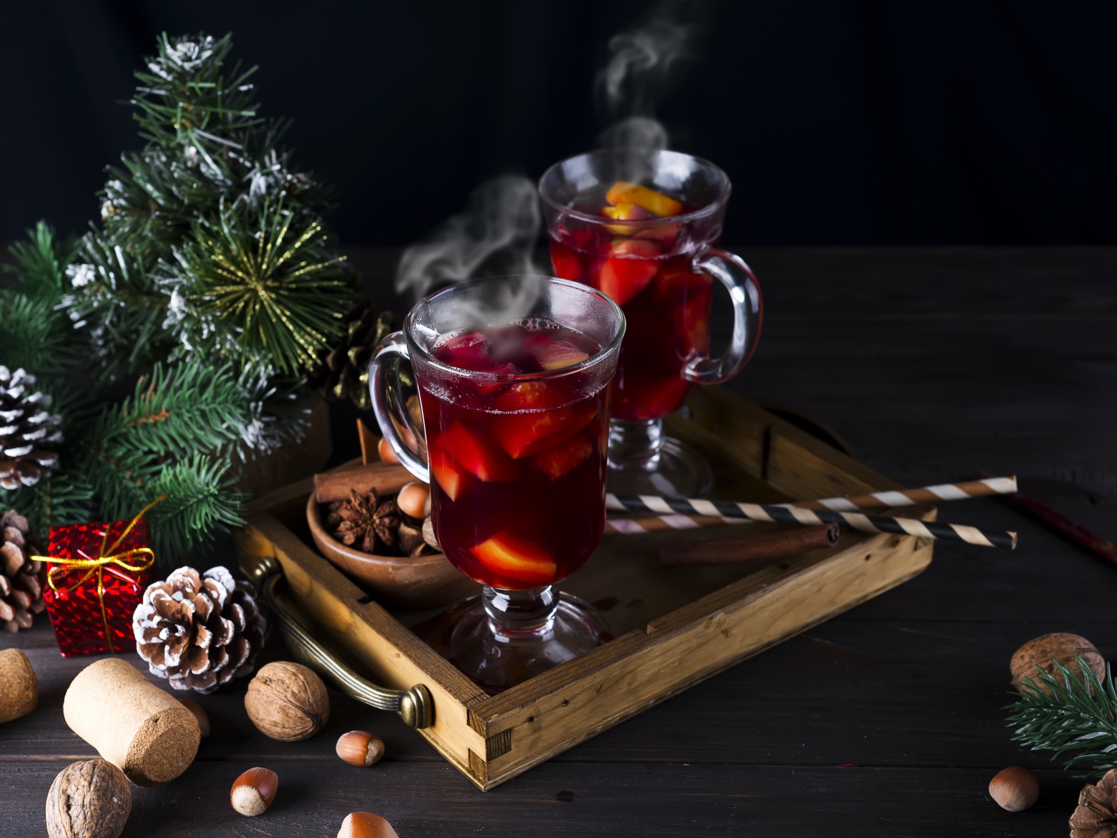 Два стакана горячего глинтвейна на столе с еловой веткой