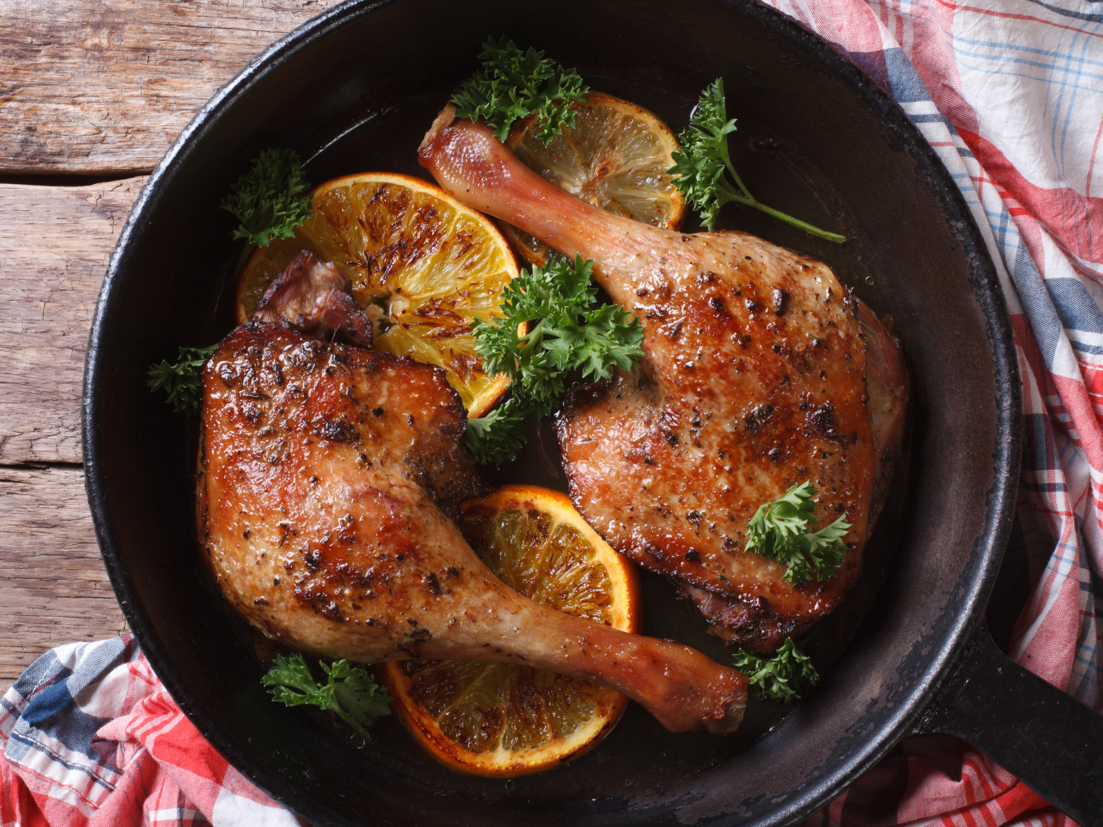 Куриные окорочка в сковороде с кольцами апельсина и петрушкой
