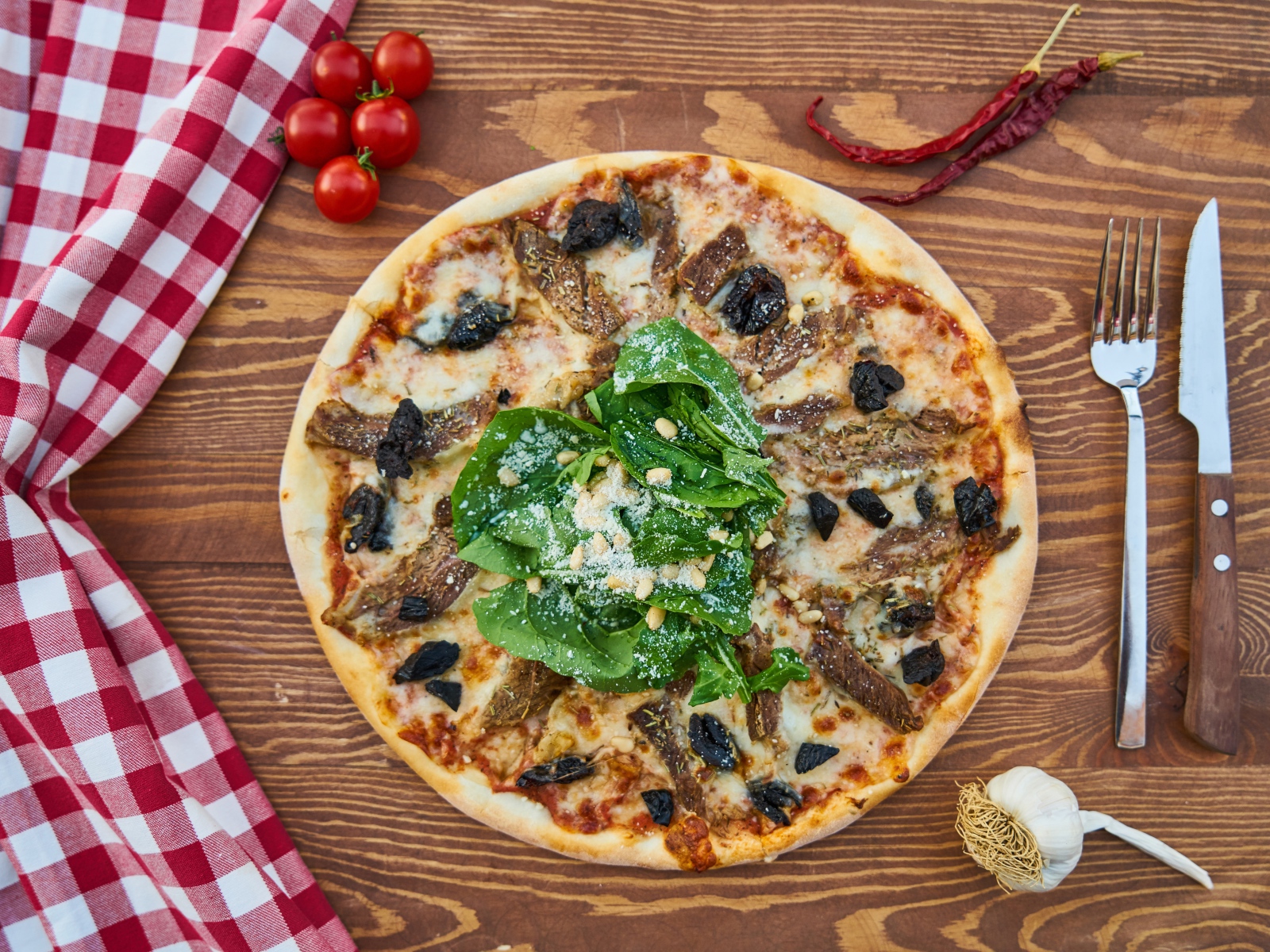 Пицца с мясом и шпинатом на столе 