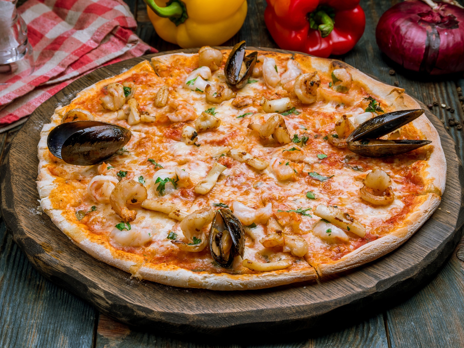 Вкусная пицца с морепродуктами на деревянной доске