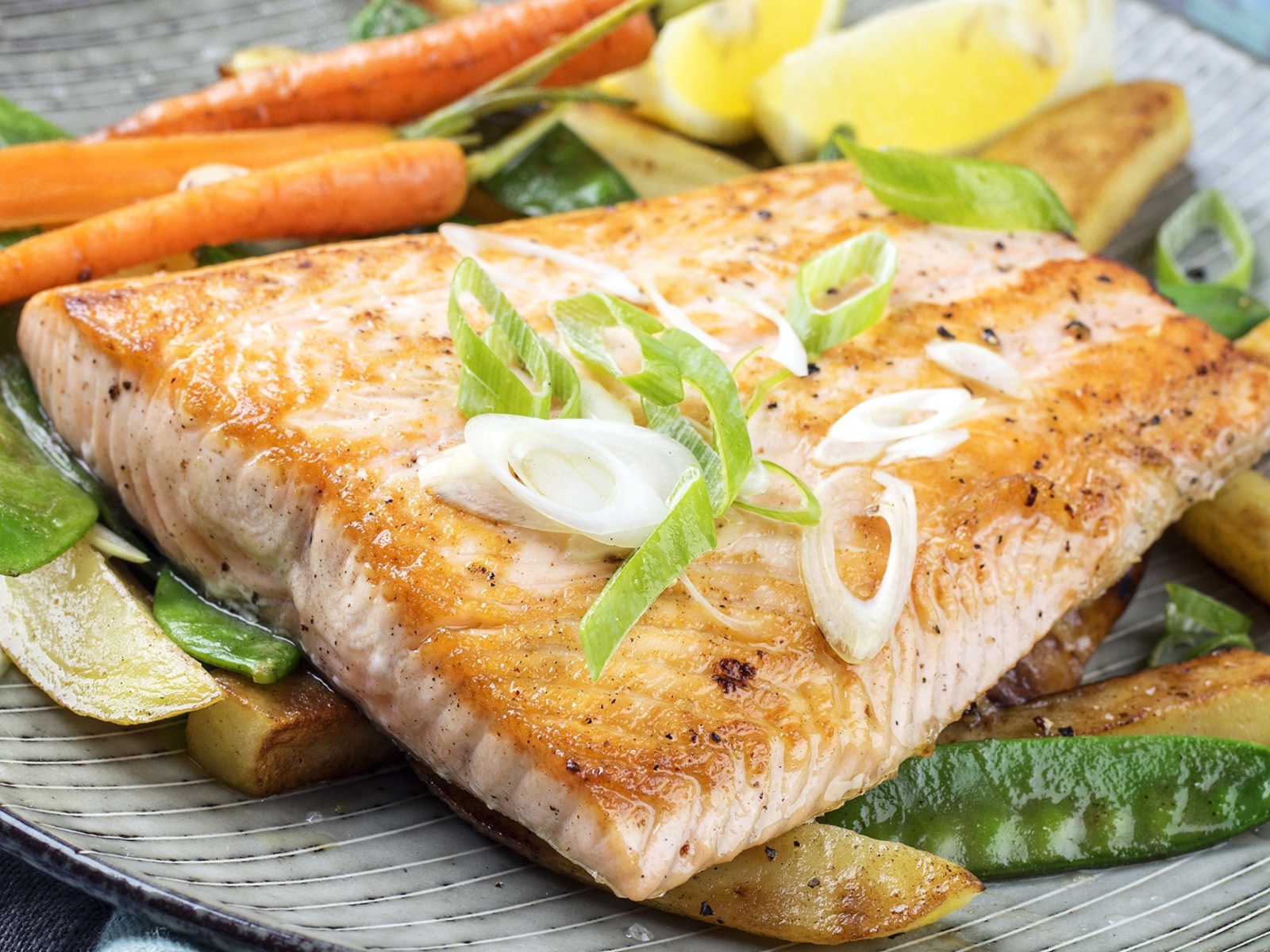 Запеченная красная рыба с овощами на тарелке