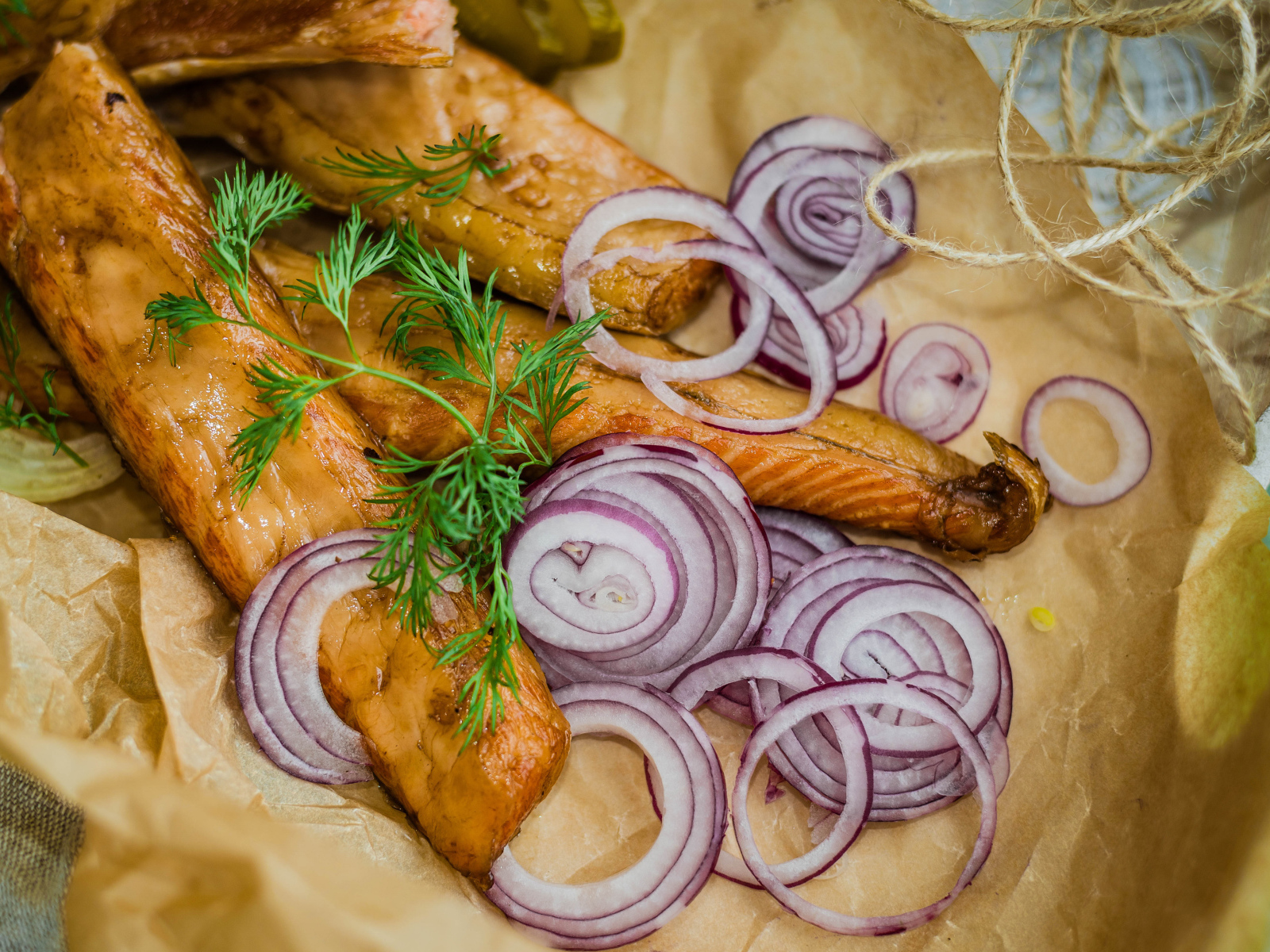 Копченое филе рыбы на бумаге с луком