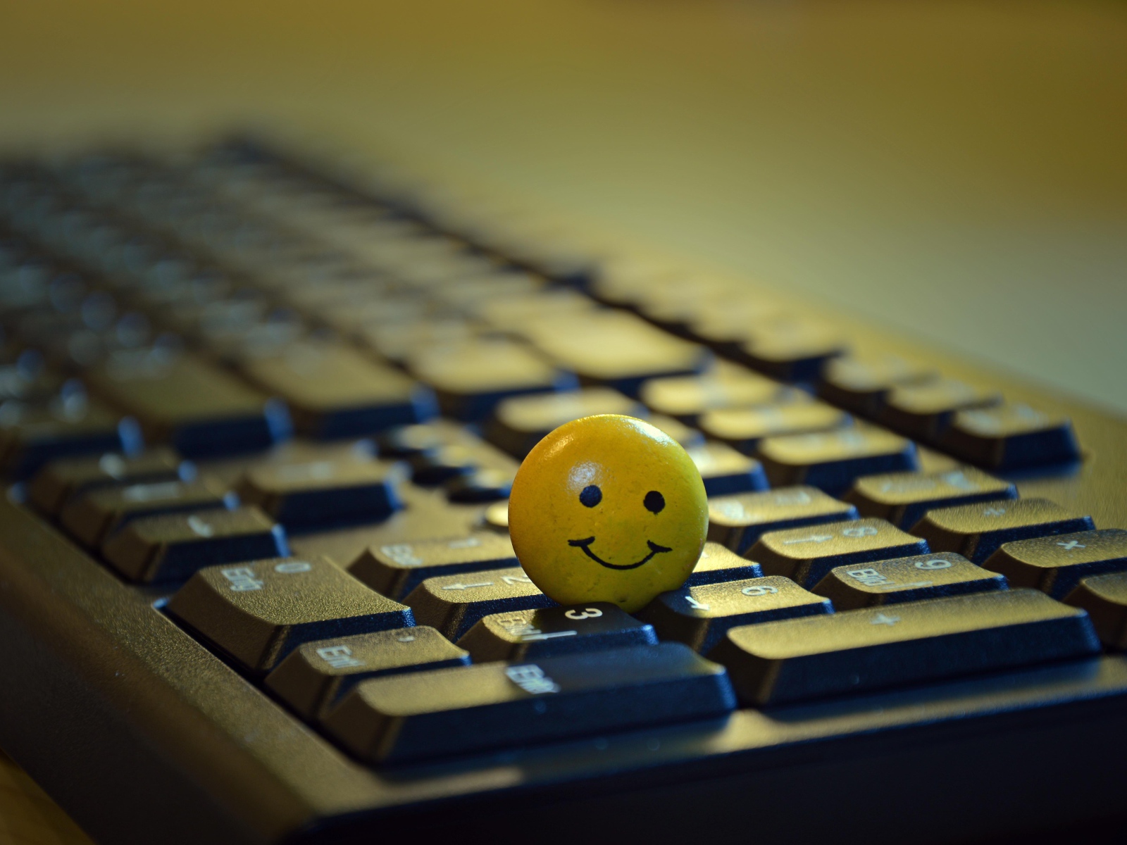 Yellow smiley face on black keyboard