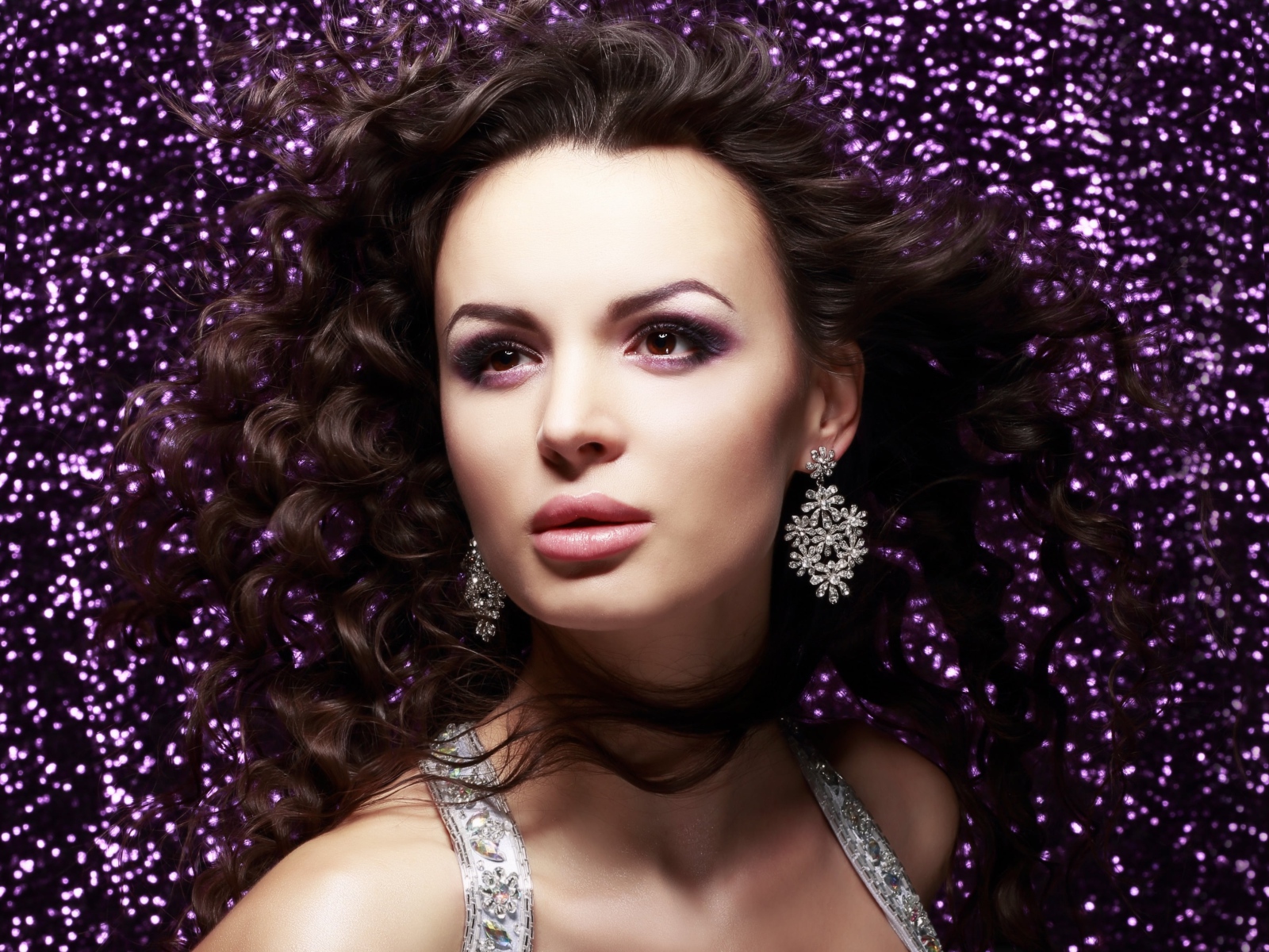 Красивая шатенка на блестящем фоне