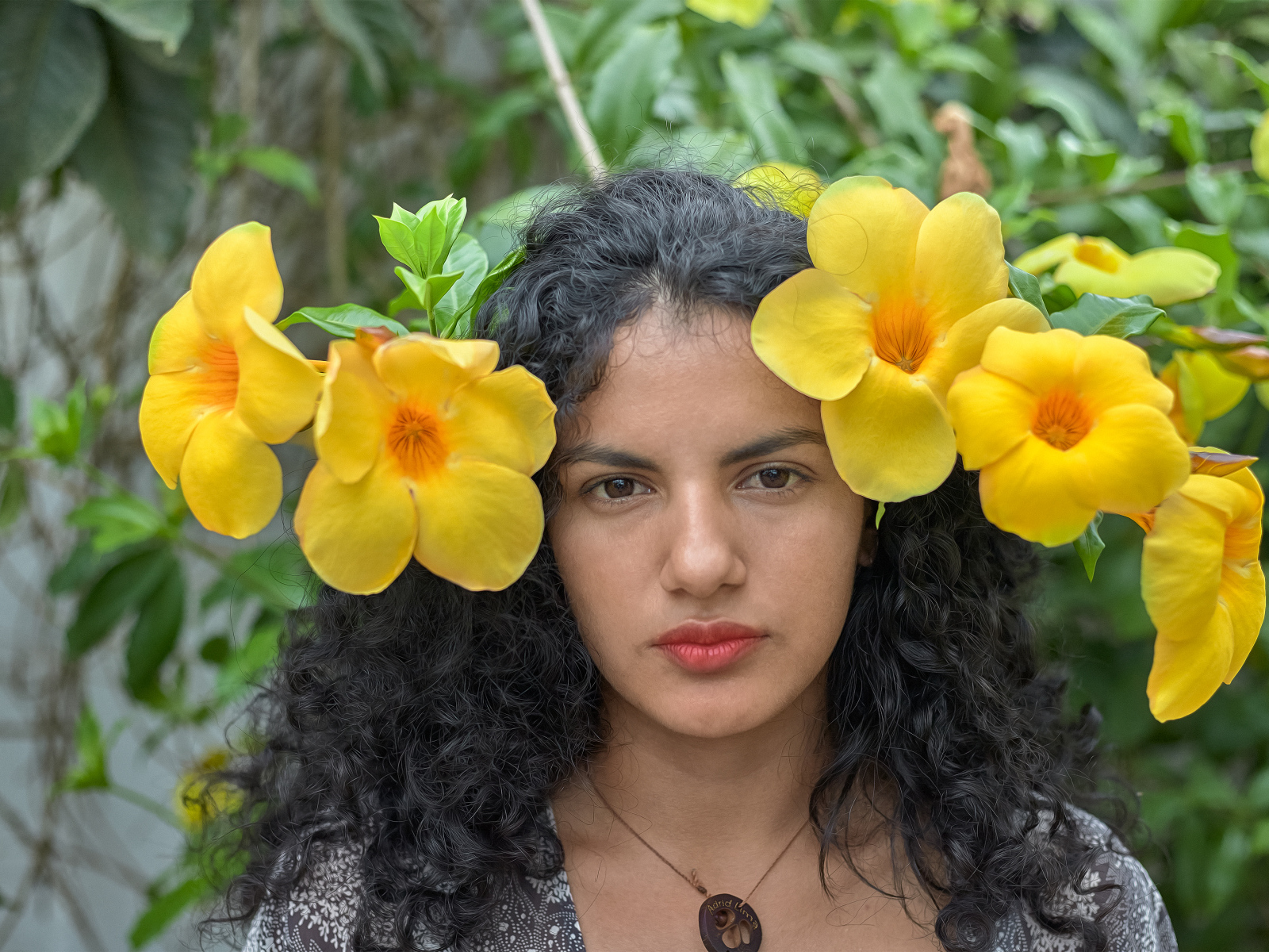 Красивая брюнетка с большими желтыми цветами в волосах 