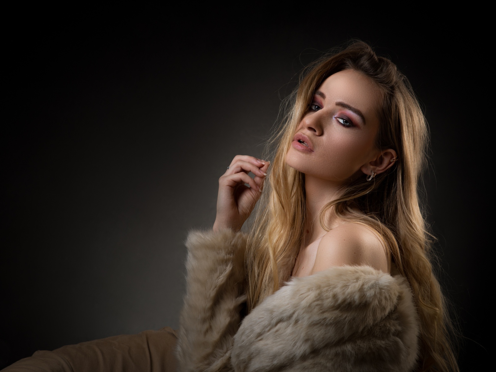 Красивая девушка в шубе на сером фоне