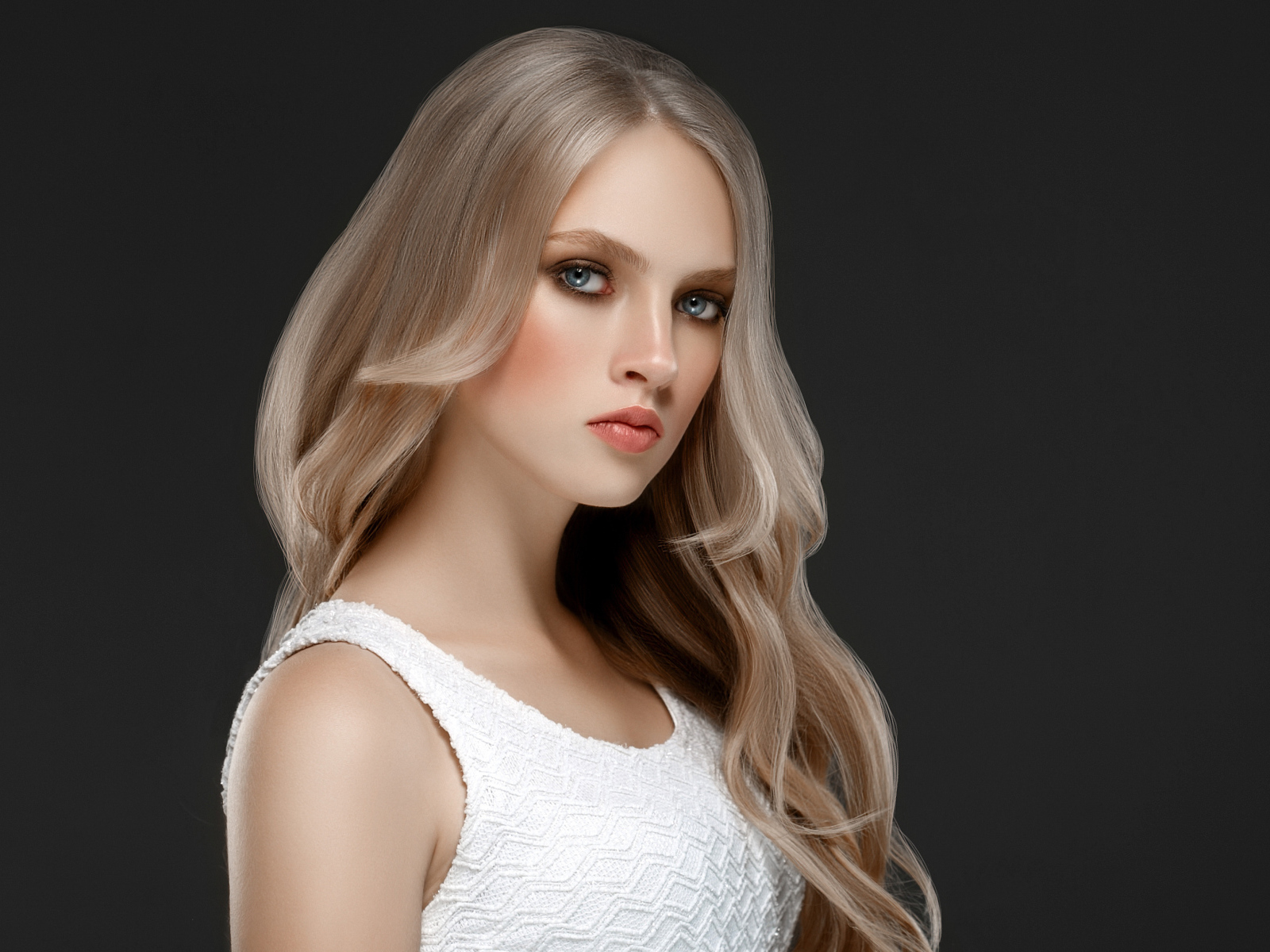 Красивая девушка с длинными  белыми волосами на сером фоне