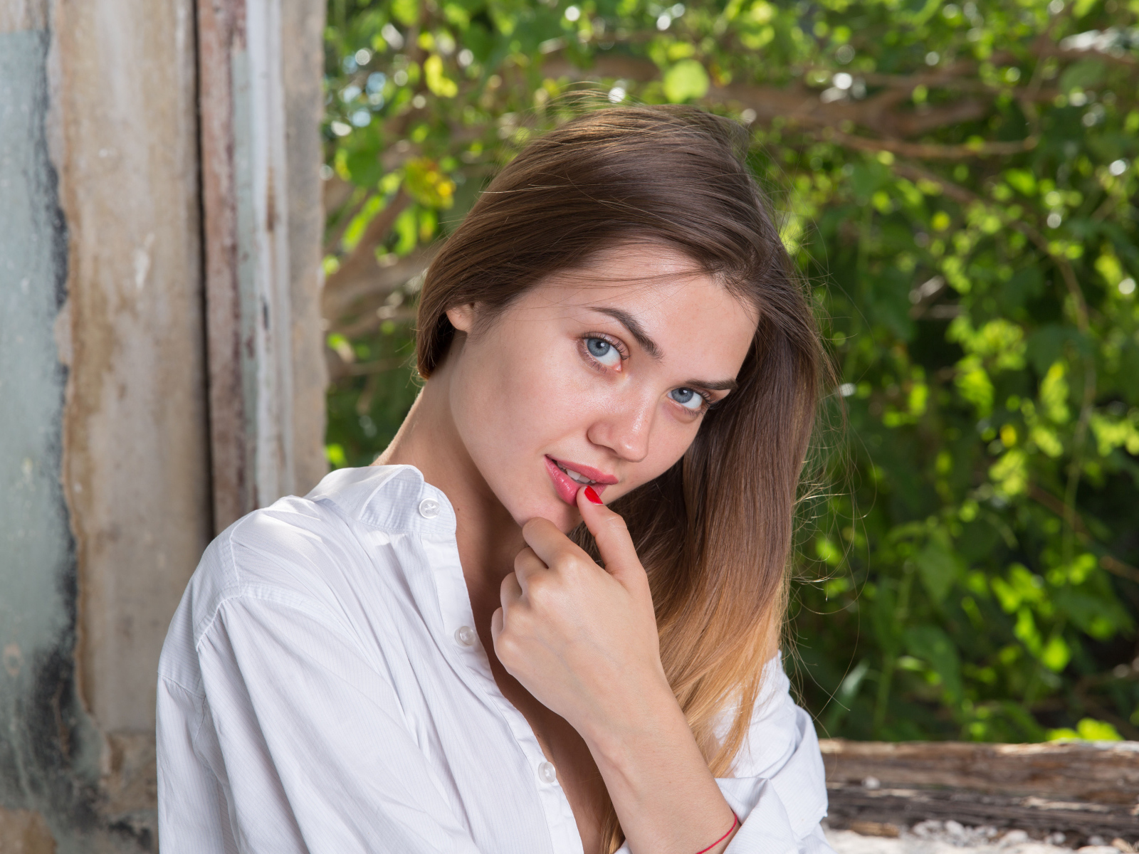 Красивая нежная девушка с серыми глазами с пальцем у рта