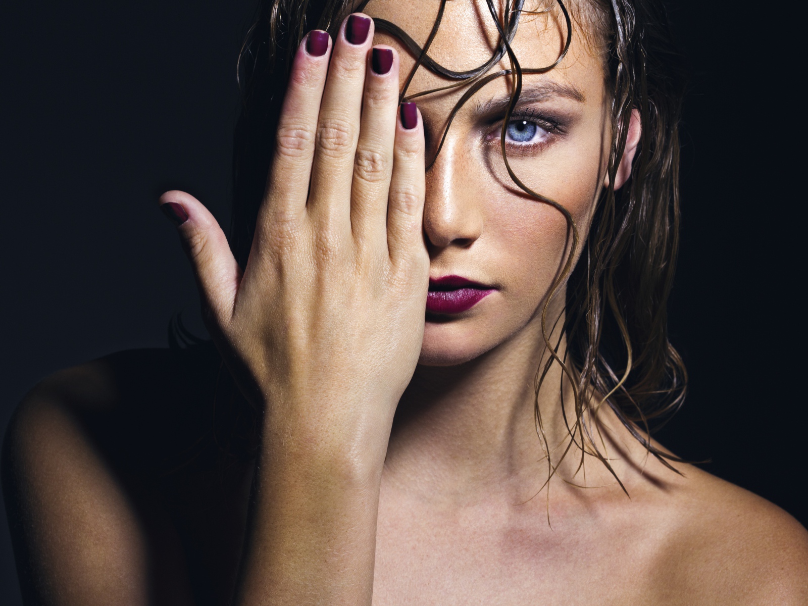 Голубоглазая девушка закрывает лицо рукой