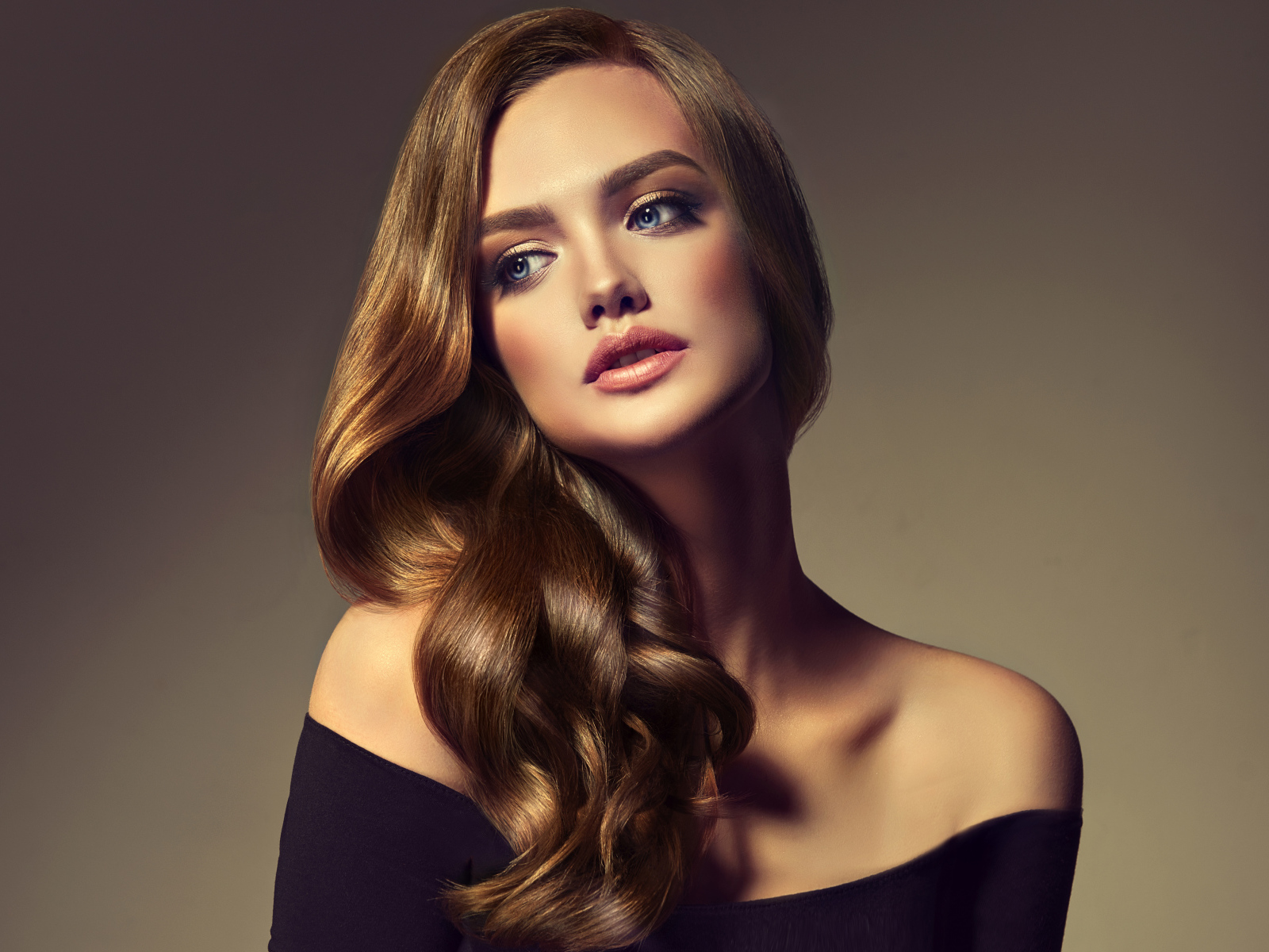 Нежная голубоглазая модель с длинными волосами на сером фоне