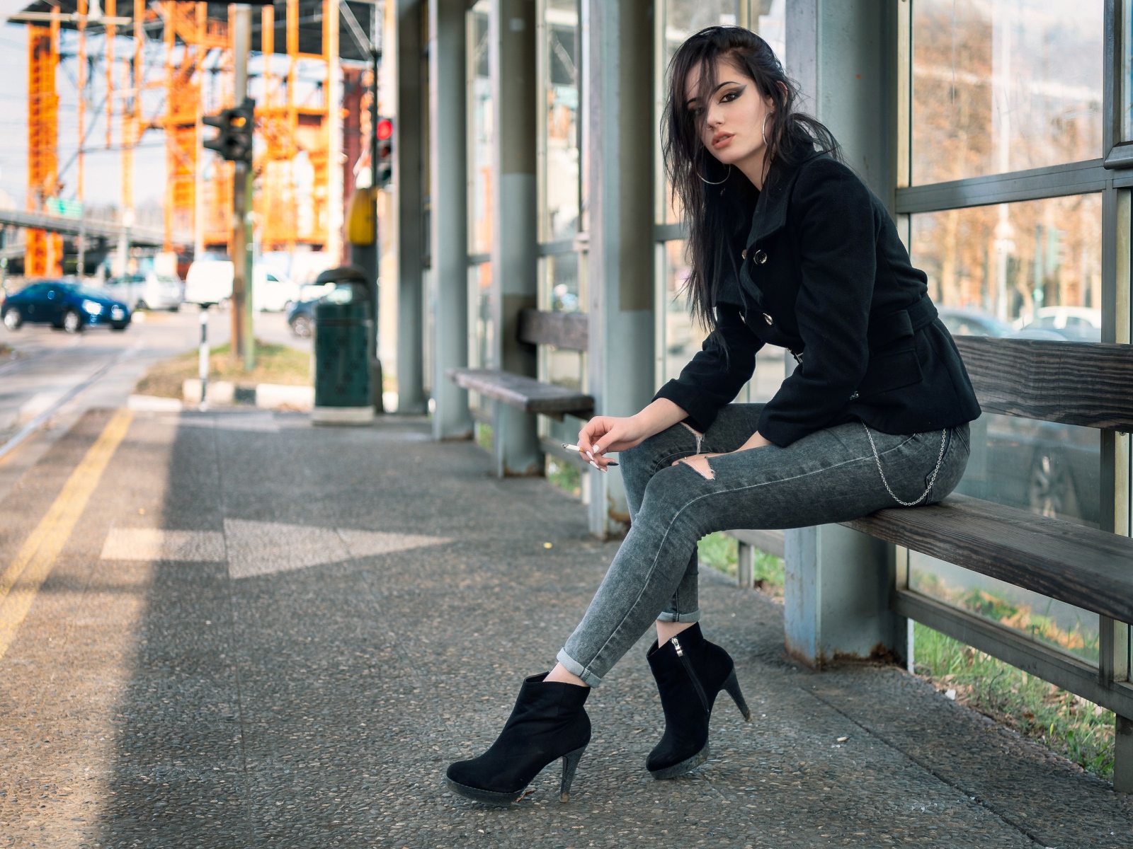 Девушка неформалка сидит на автобусной остановке