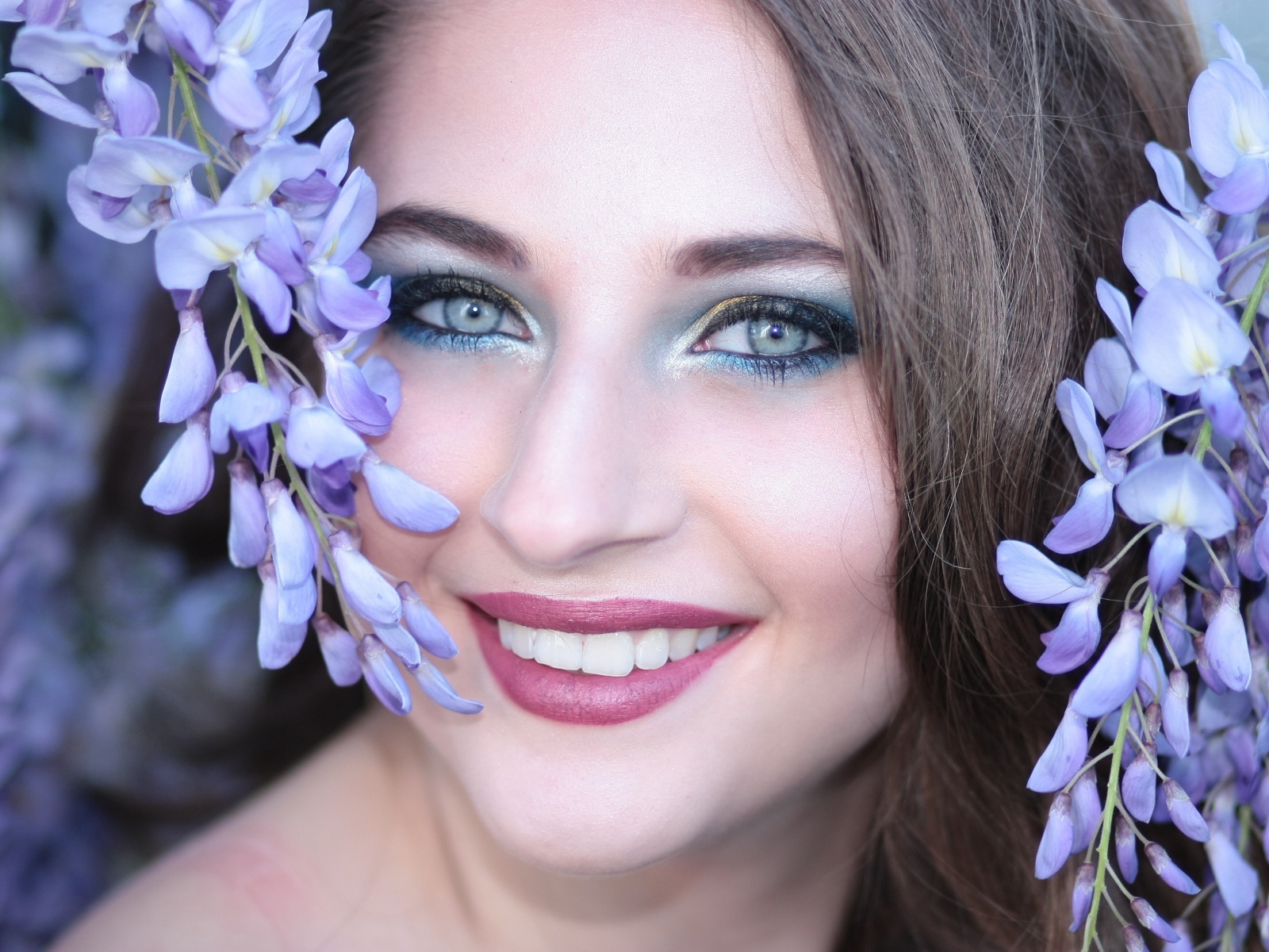 Улыбающаяся девушка с цветами глицинии