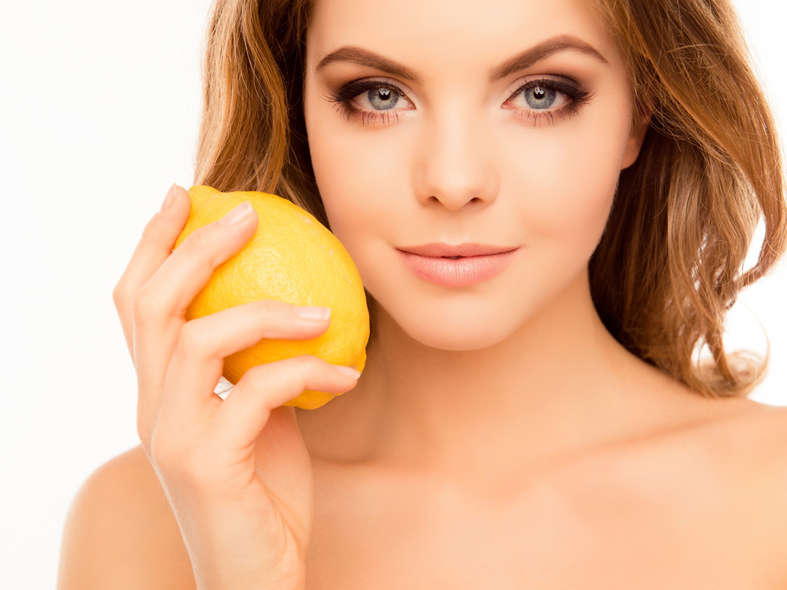 Нежная голубоглазая девушка с лимоном в руке