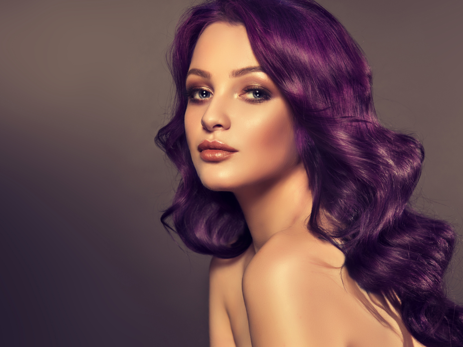 Девушка с фиолетовыми волосами на сером фоне