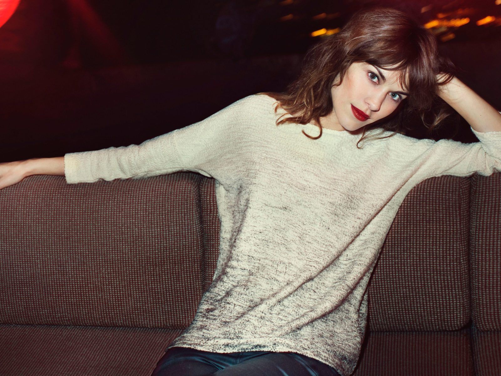 Красивая девушка модель Алекса Чанг сидит на диване