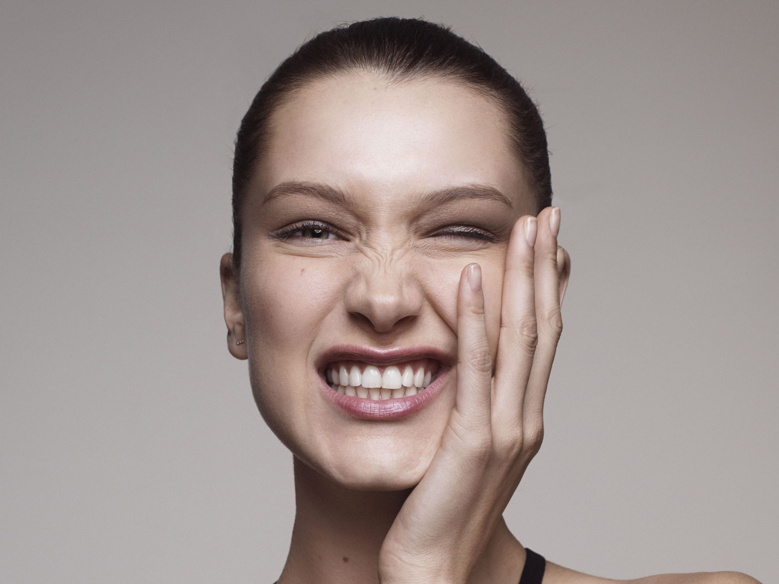 Модель Белла Хадид корчит гримасы на сером фоне