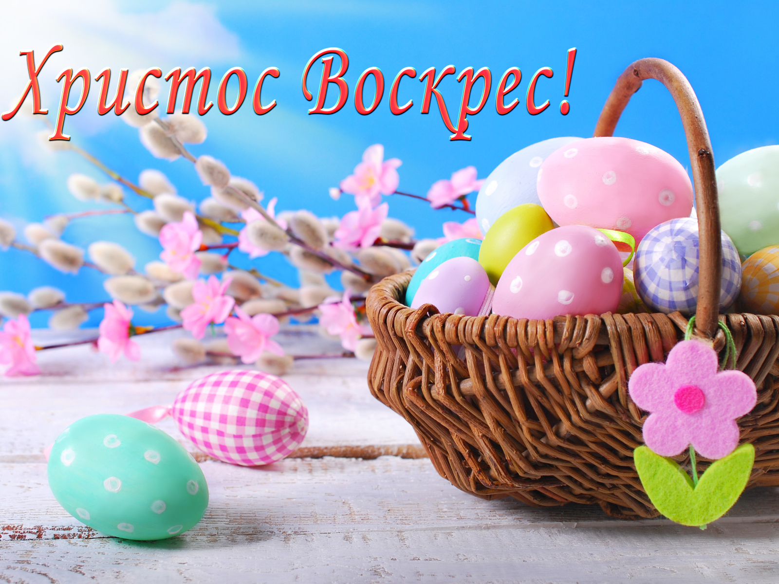 Корзина крашеных яиц на голубом фоне с надписью Христос Воскрес! 