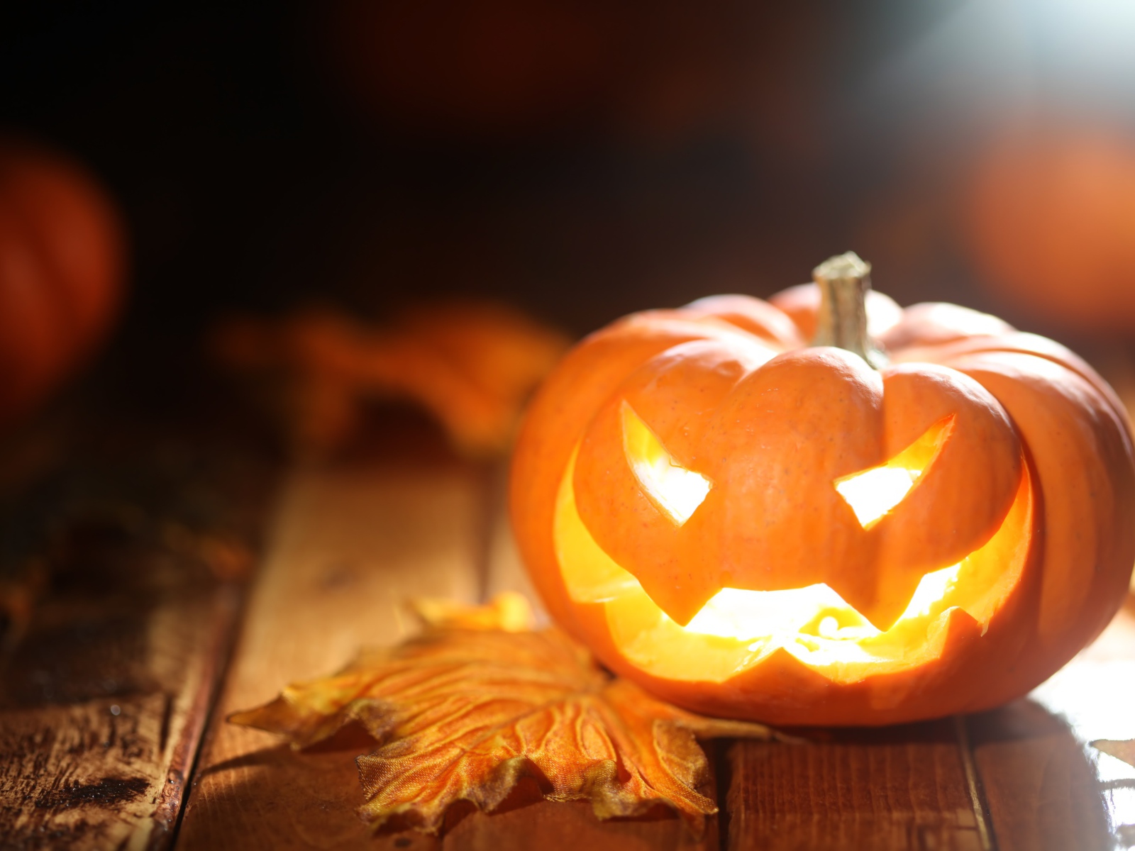 Светящаяся тыква на столе на Хэллоуин