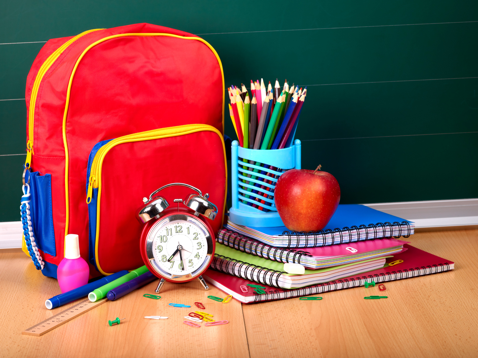 Backpack, notebooks, pencils, an alarm clock and an apple on Knowledge Day on September 1