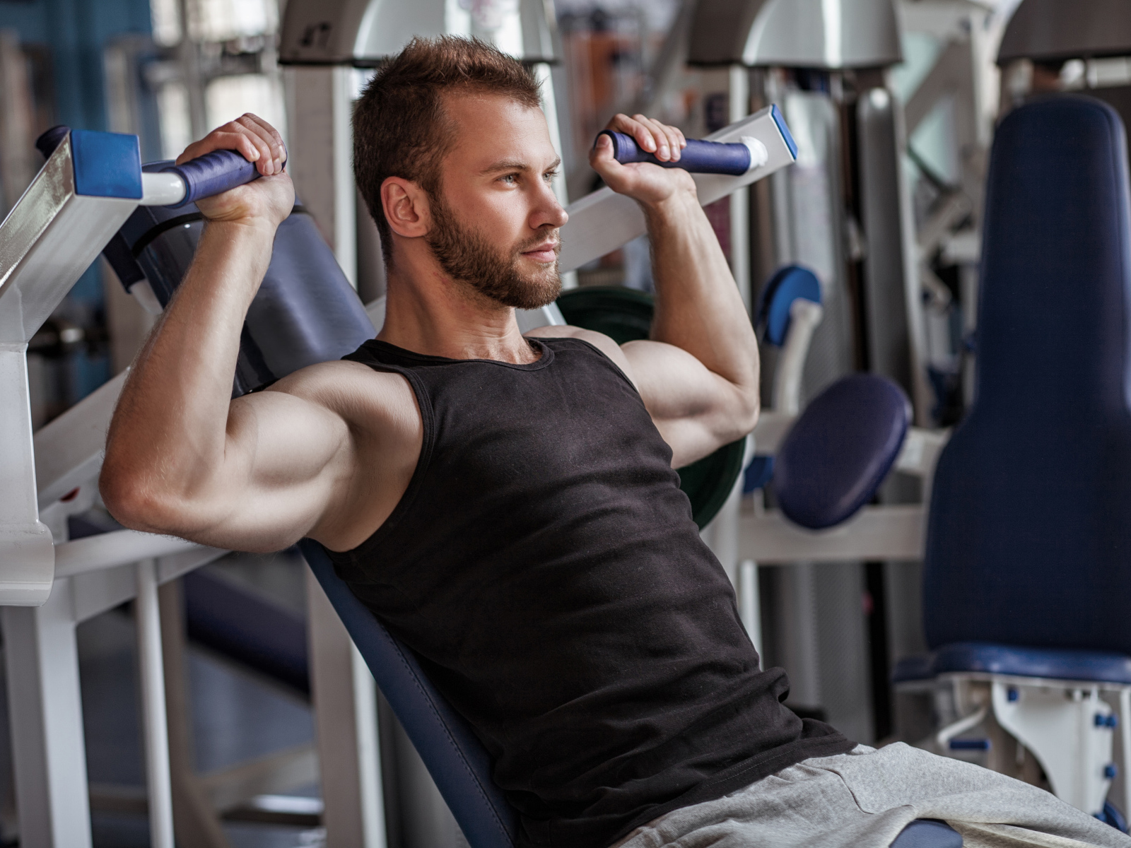 Накаченный мужчина занимается в спортзале
