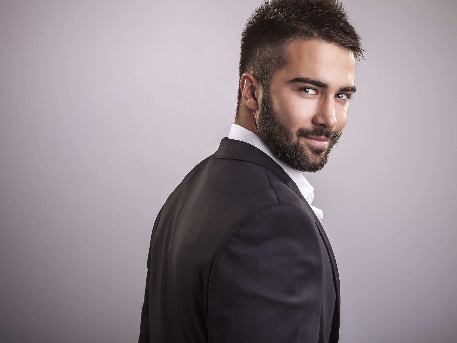 Красивый мужчина модель с бородой на сером фоне