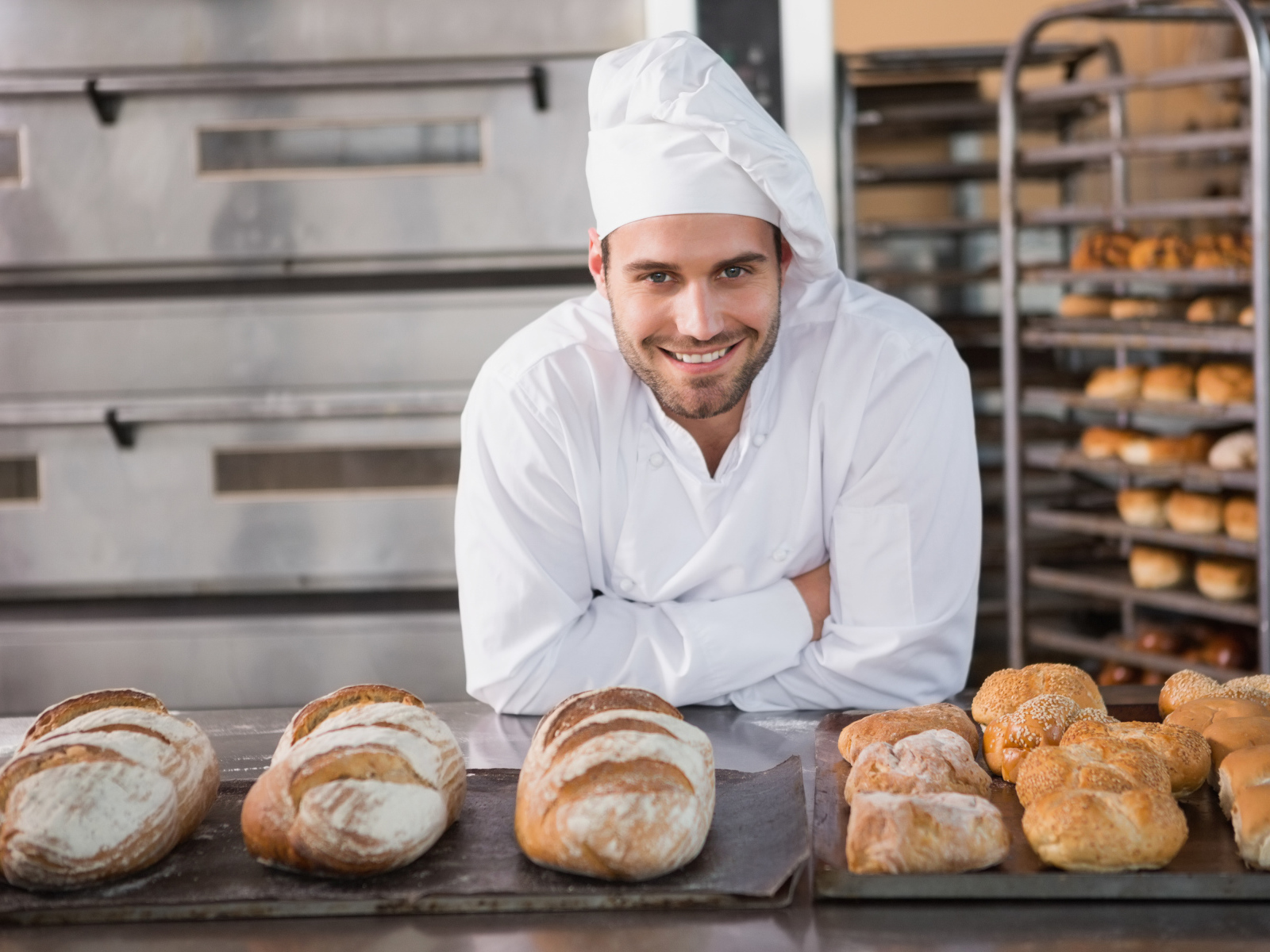 Красивый улыбающийся мужчина пекарь в форме