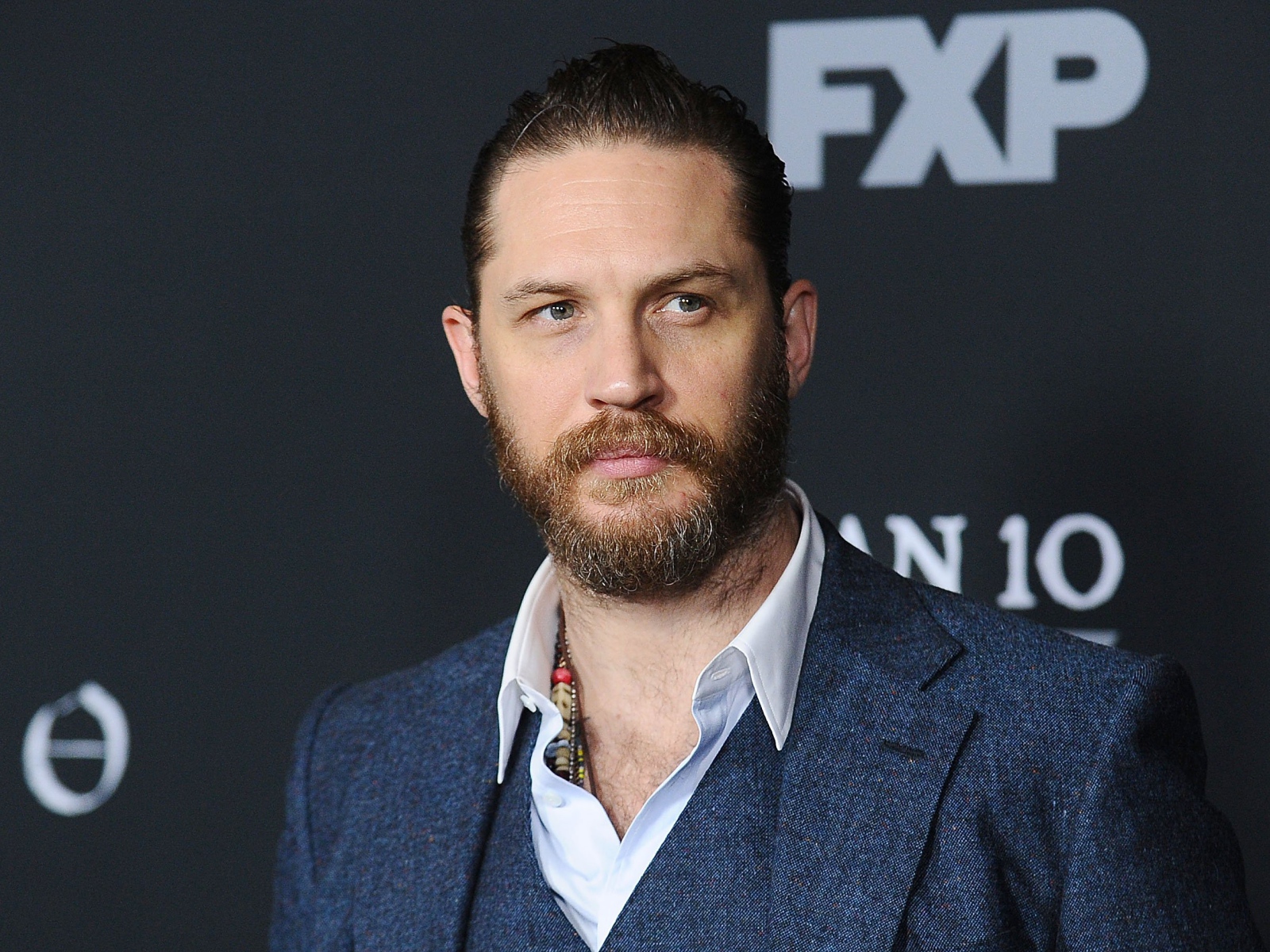 Актер Том Харди с бородой в костюме