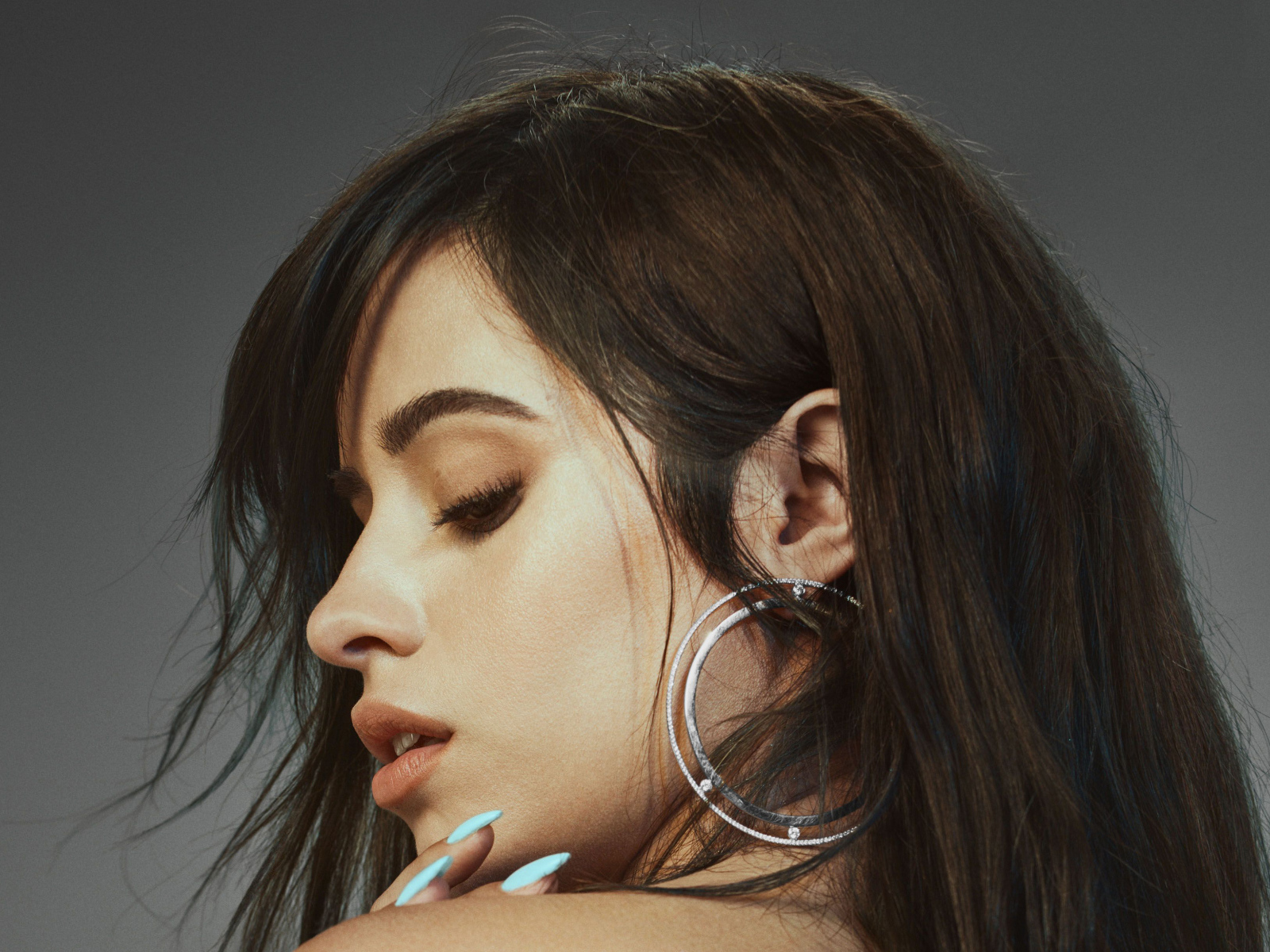 Певица Камила Кабельо на сером фоне крупным планом 