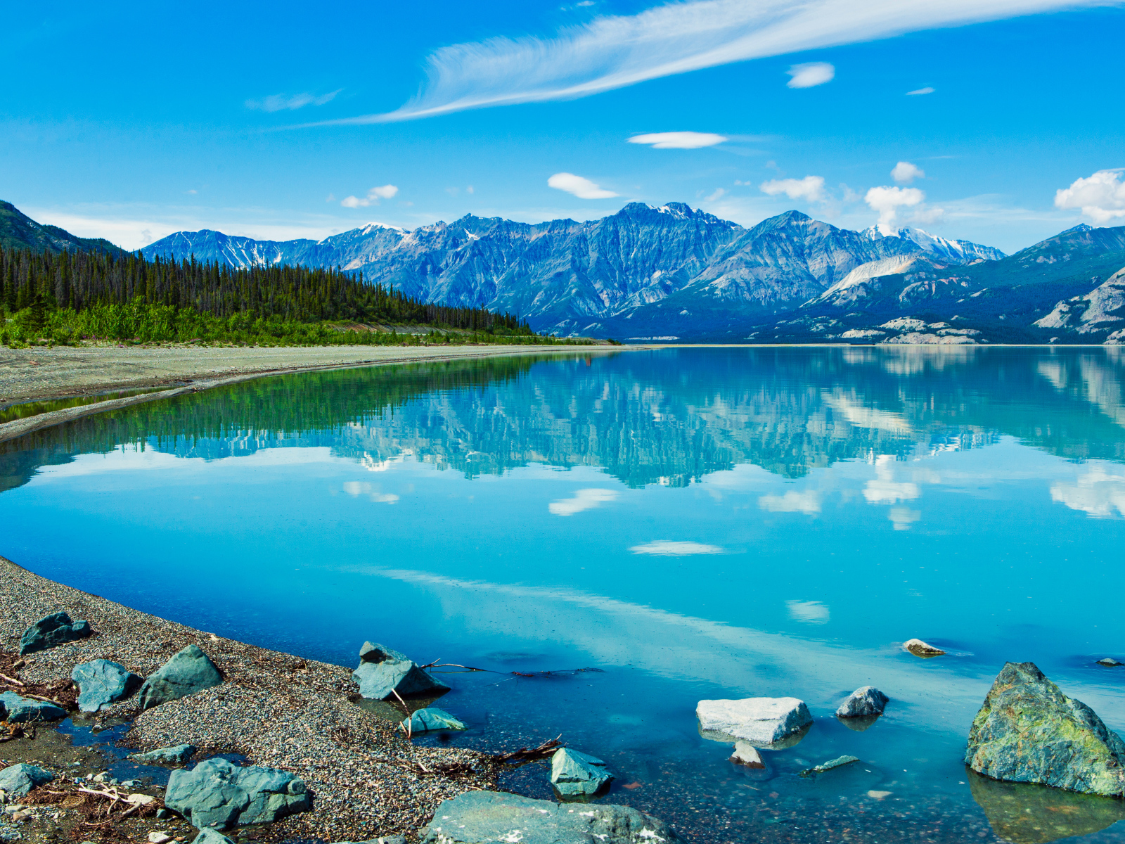 Красивое голубое озеро у заснеженных гор