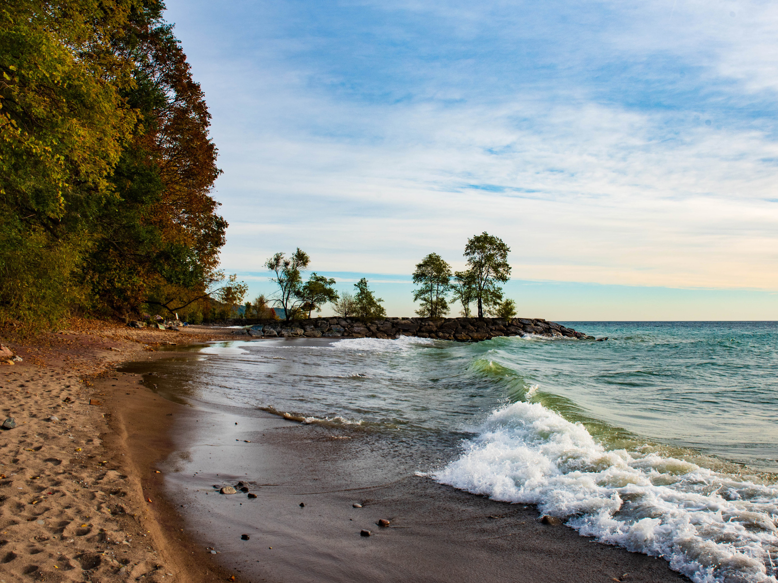 Белые волны океана на мокром песке под красивым небом
