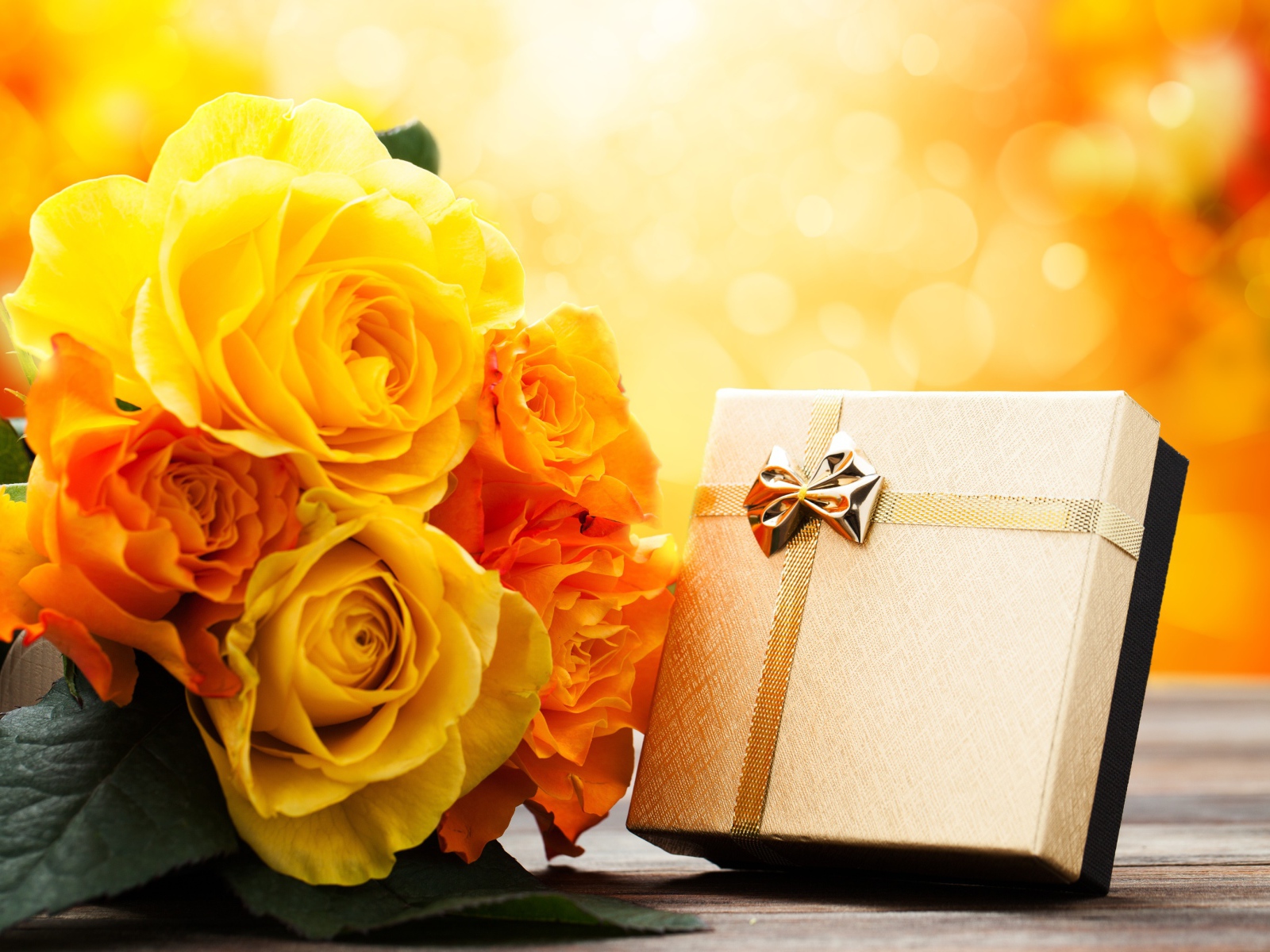 Подарок с букетом желтых роз на столе 