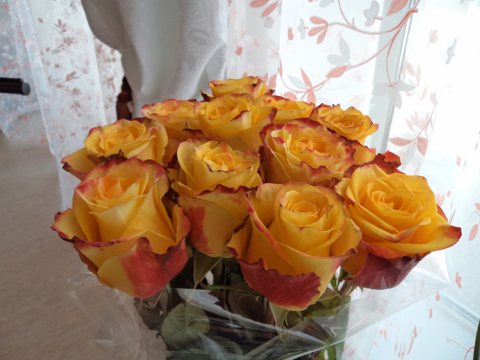 Красивый букет желтых роз в вазе у окна