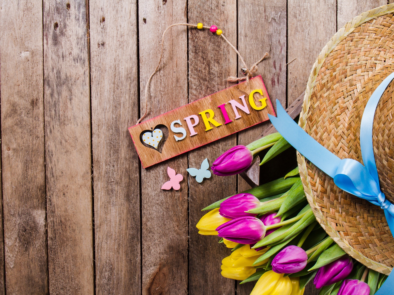 Надпись на английском весна на столе с букетом тюльпанов и шляпой