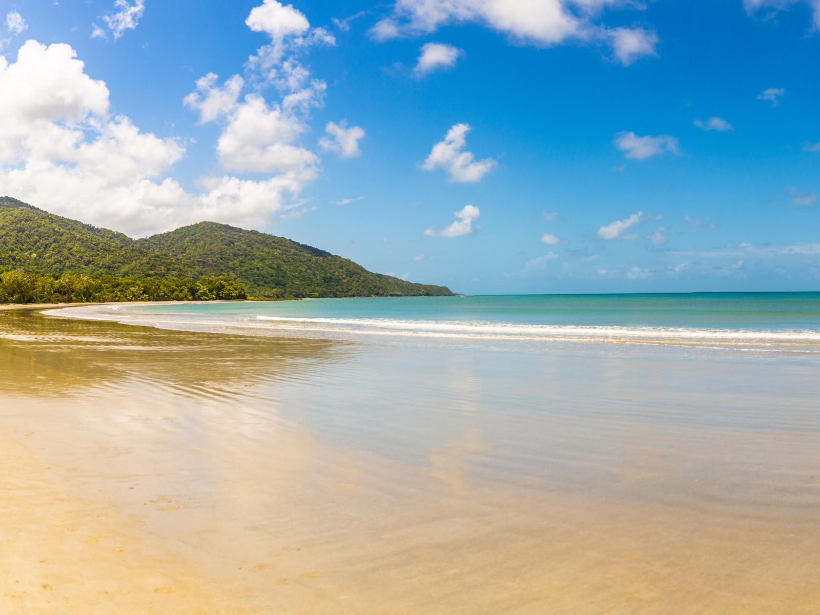 Спокойные волны на песке под красивым голубым небом
