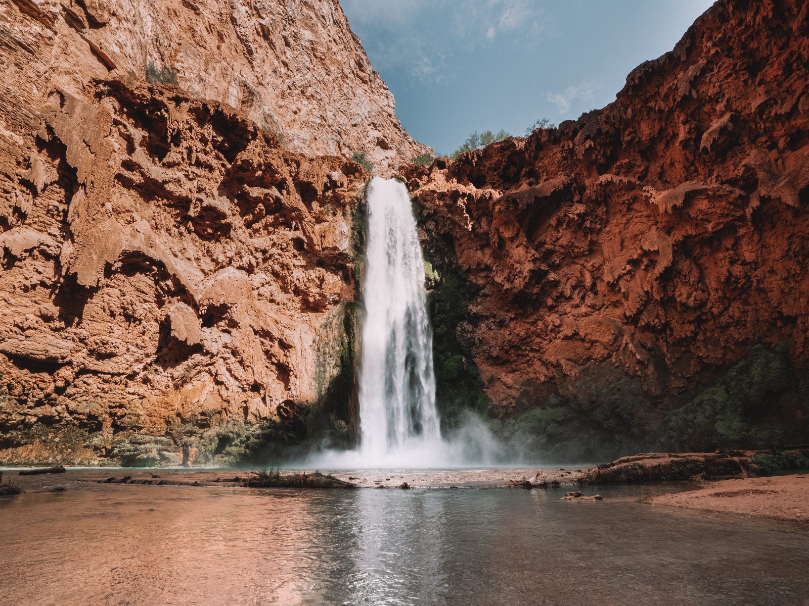 Водопад стекает со скалы в озеро 