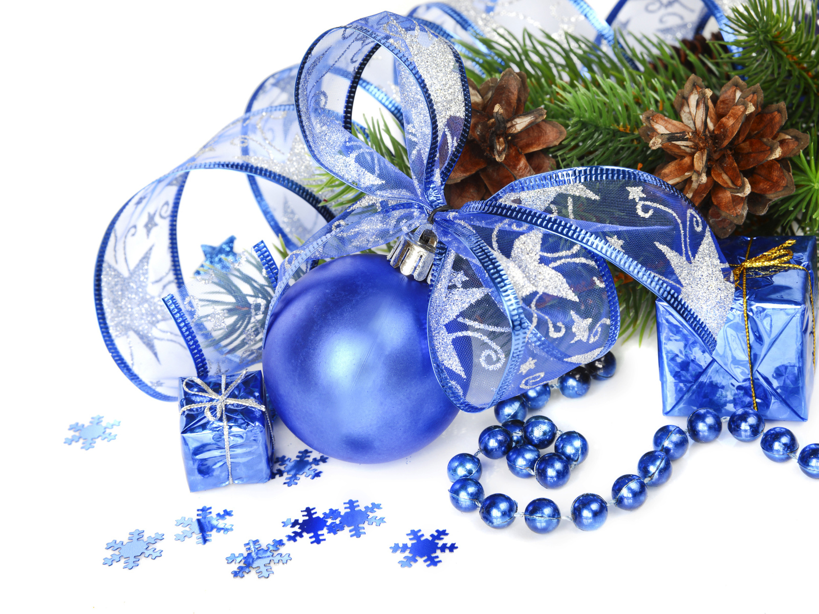 Красивый синий елочный шар с лентой на белом фоне с елочной веткой