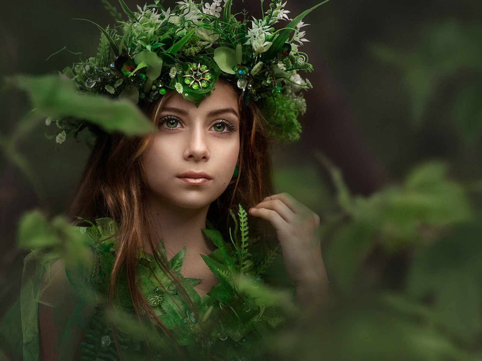 Красивая голубоглазая девочка с венком на голове у дерева