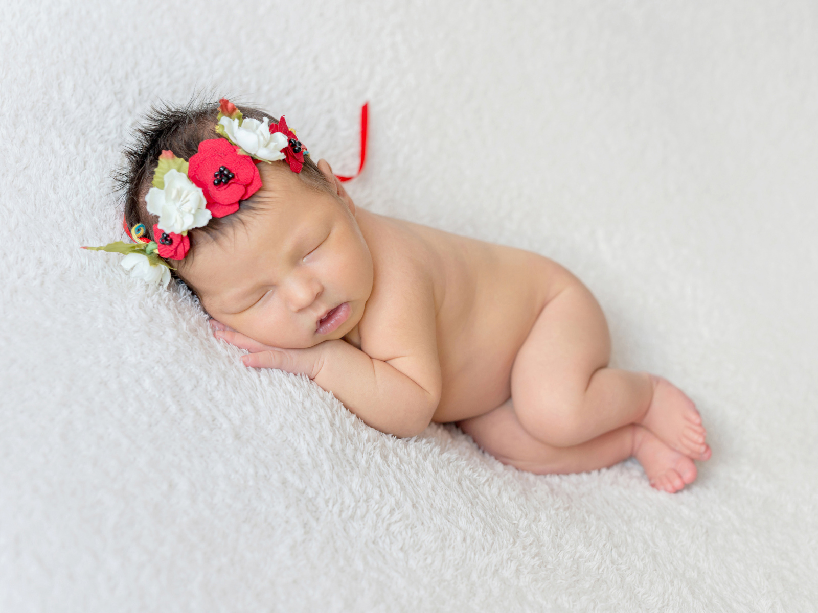 Грудная спящая девочка с венком на голове 