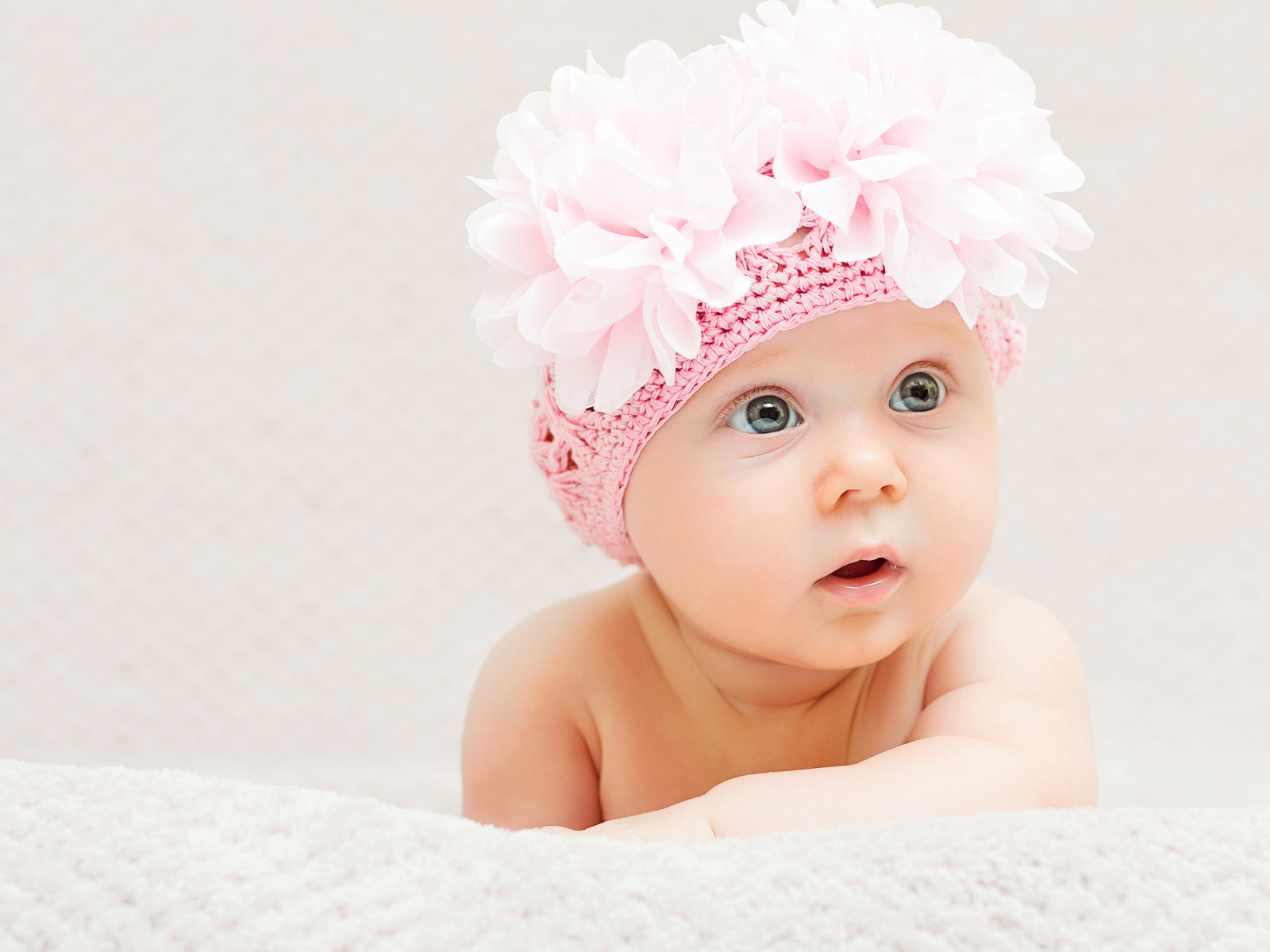 Маленькая девочка в вязаной шапке с цветами