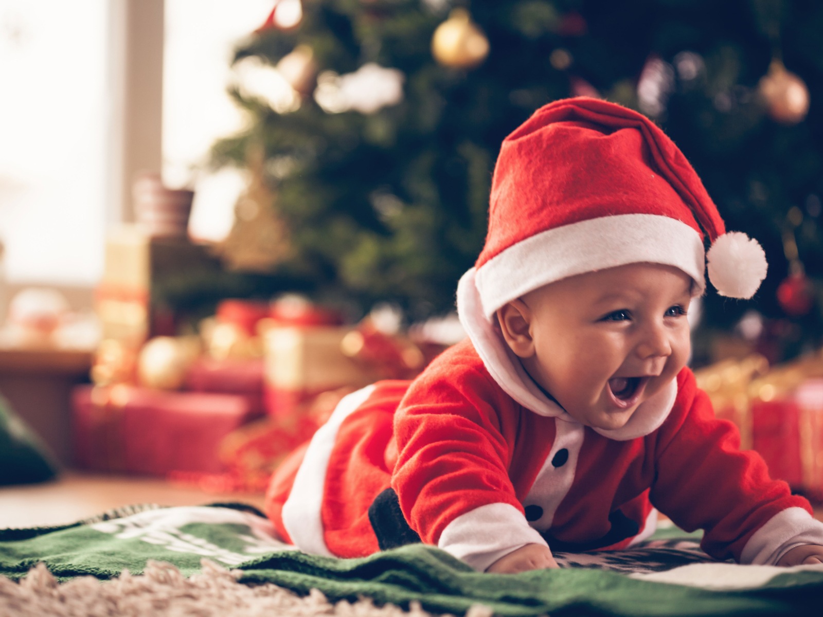 Улыбающийся малыш в новогоднем костюме у елки