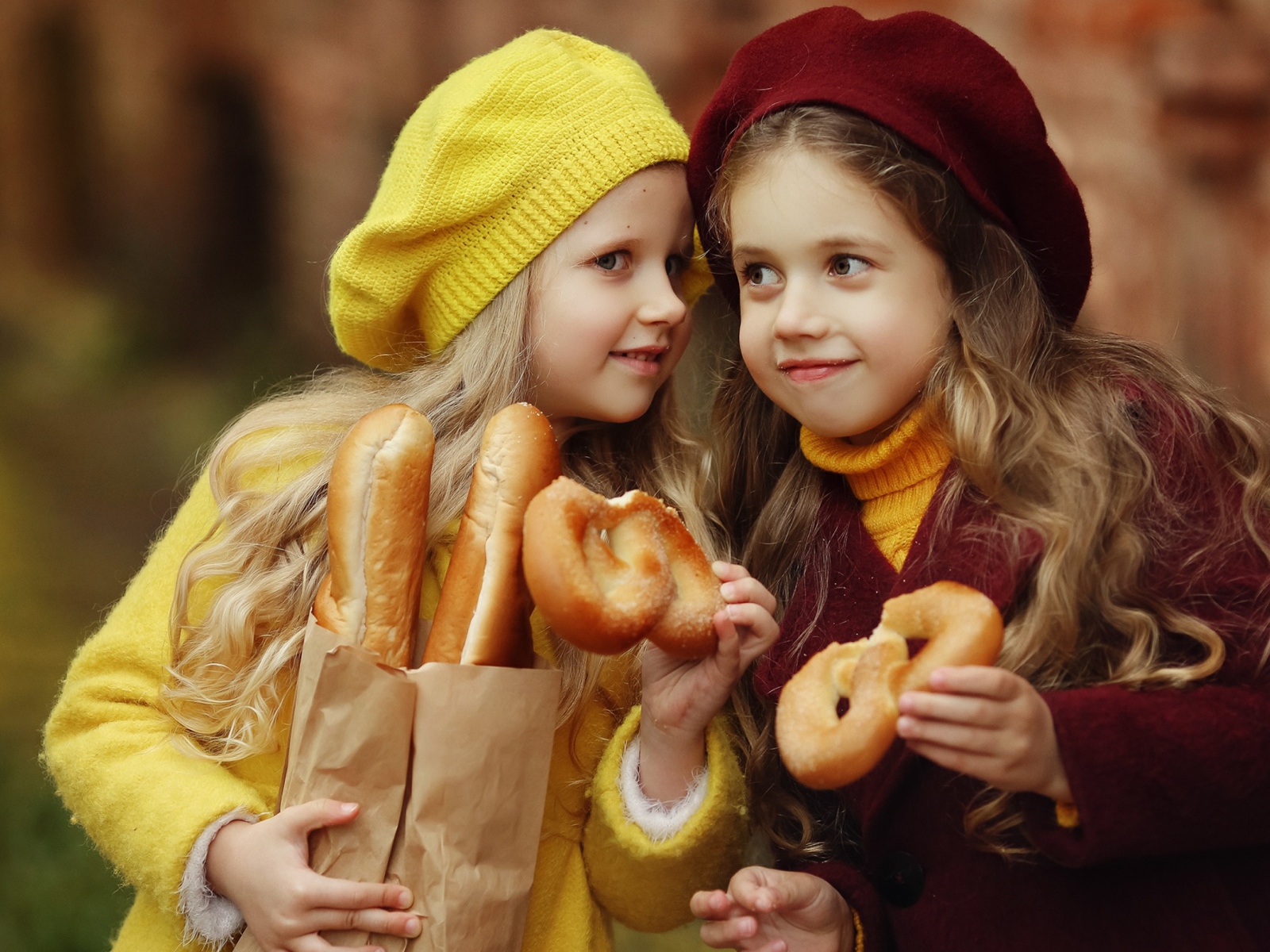 Две маленькие девочки с булочками 