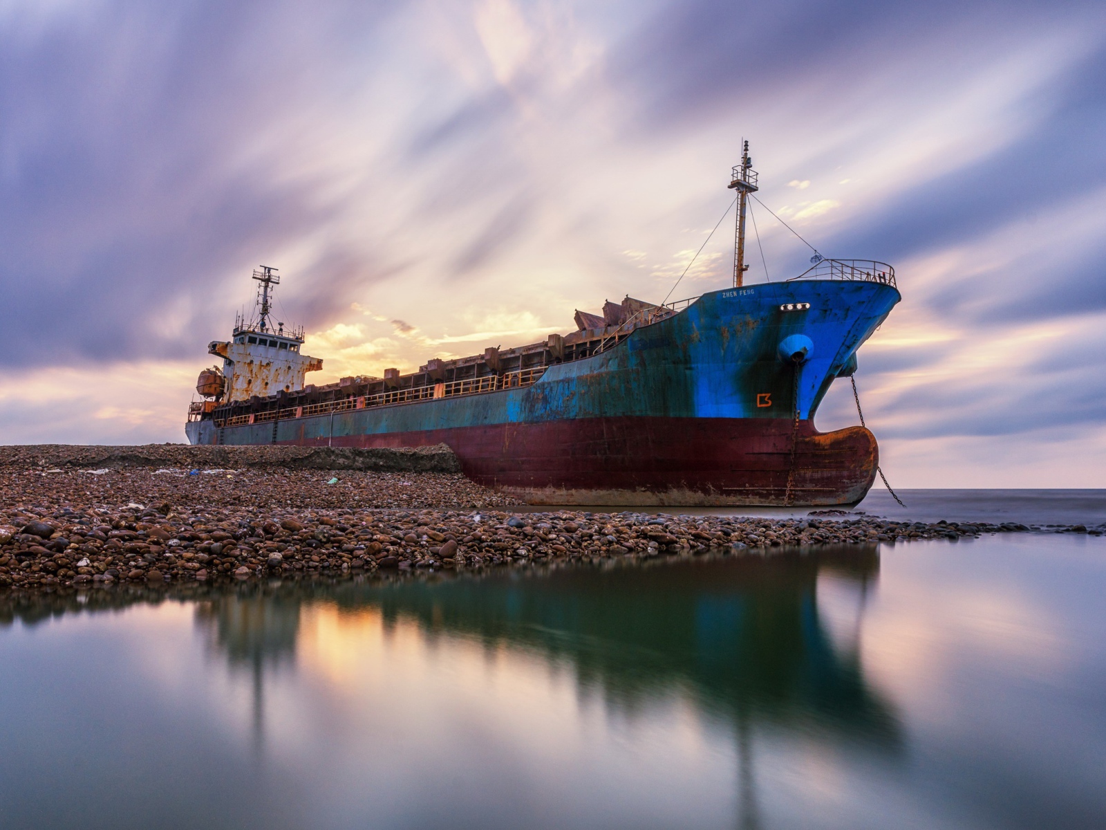 Старый ржавый корабль на берегу под красивым небом