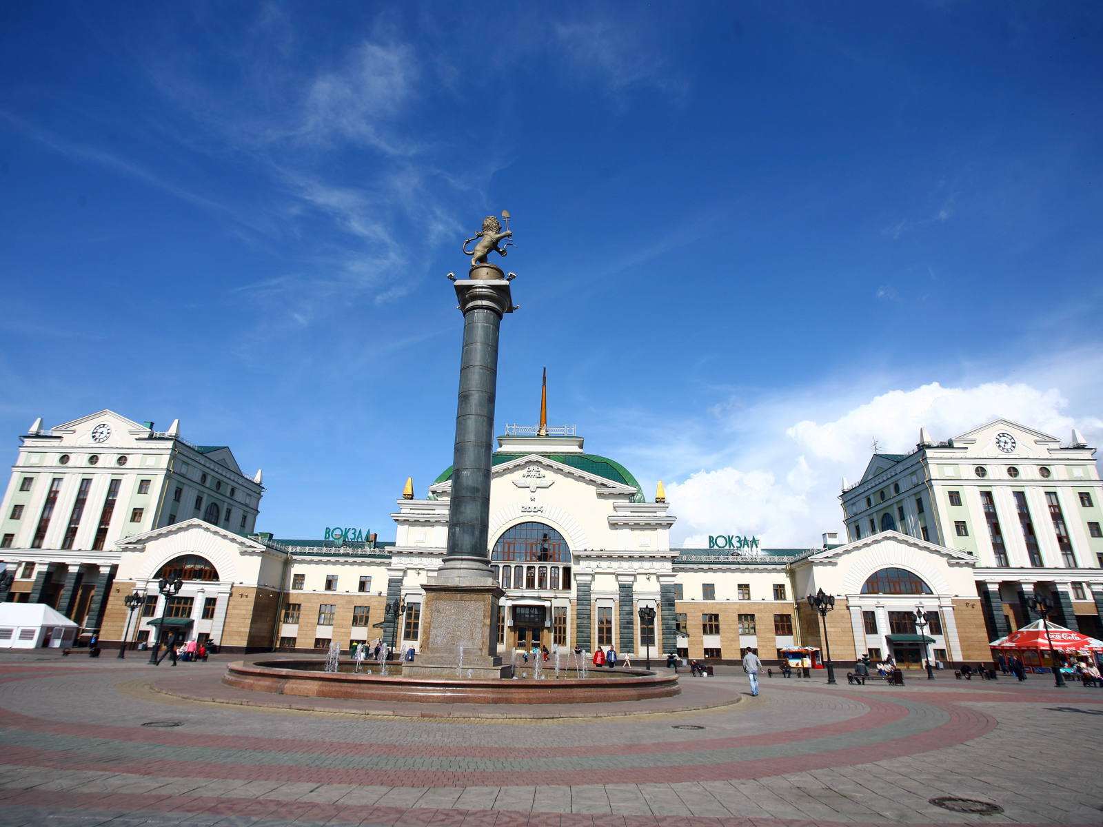 Памятник у здания железнодорожного вокзала под красивым голубым небом, Красноярск. Россия