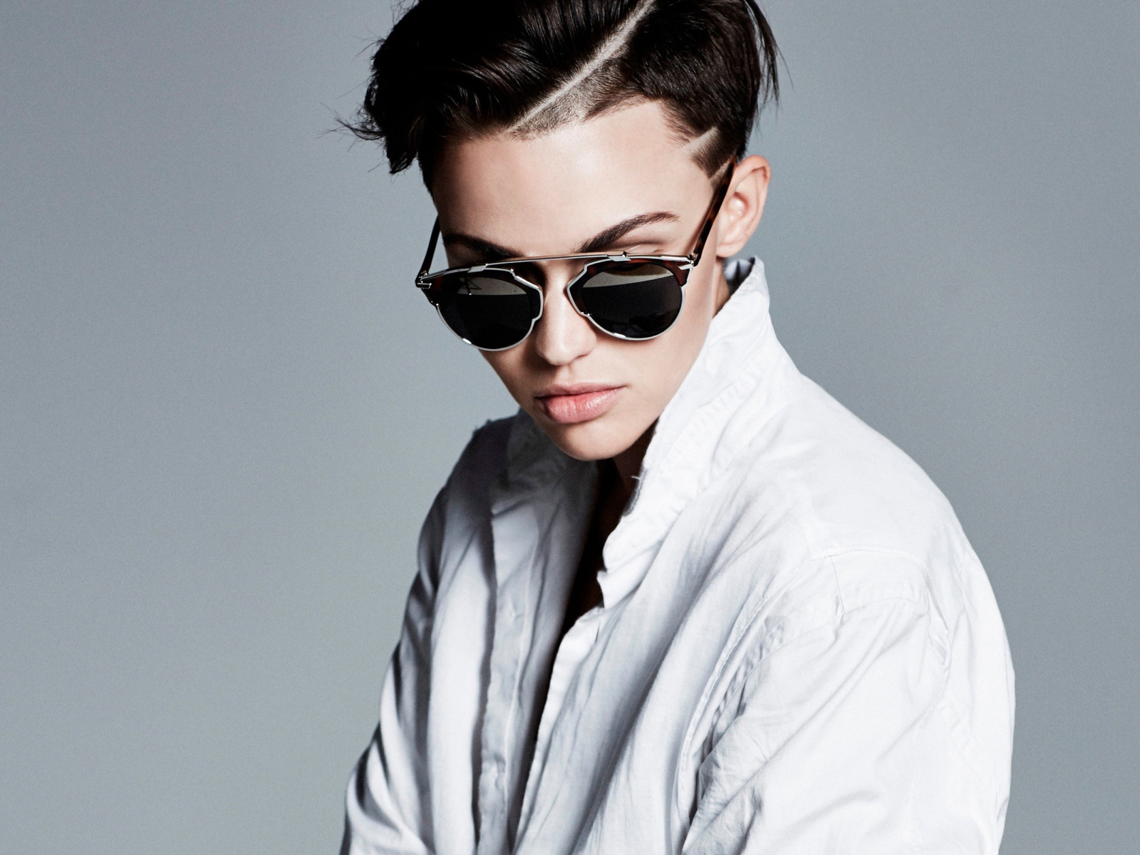 Актриса Руби Роуз в белой рубашке и очках на сером фоне