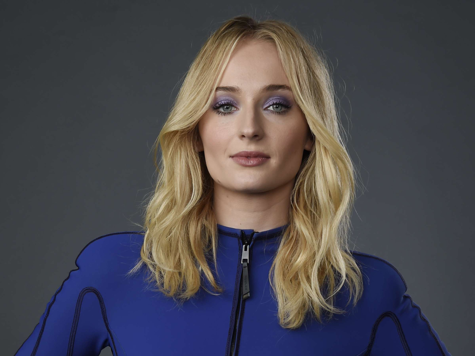 Актриса Софи Тернер крупным планом на сером фоне