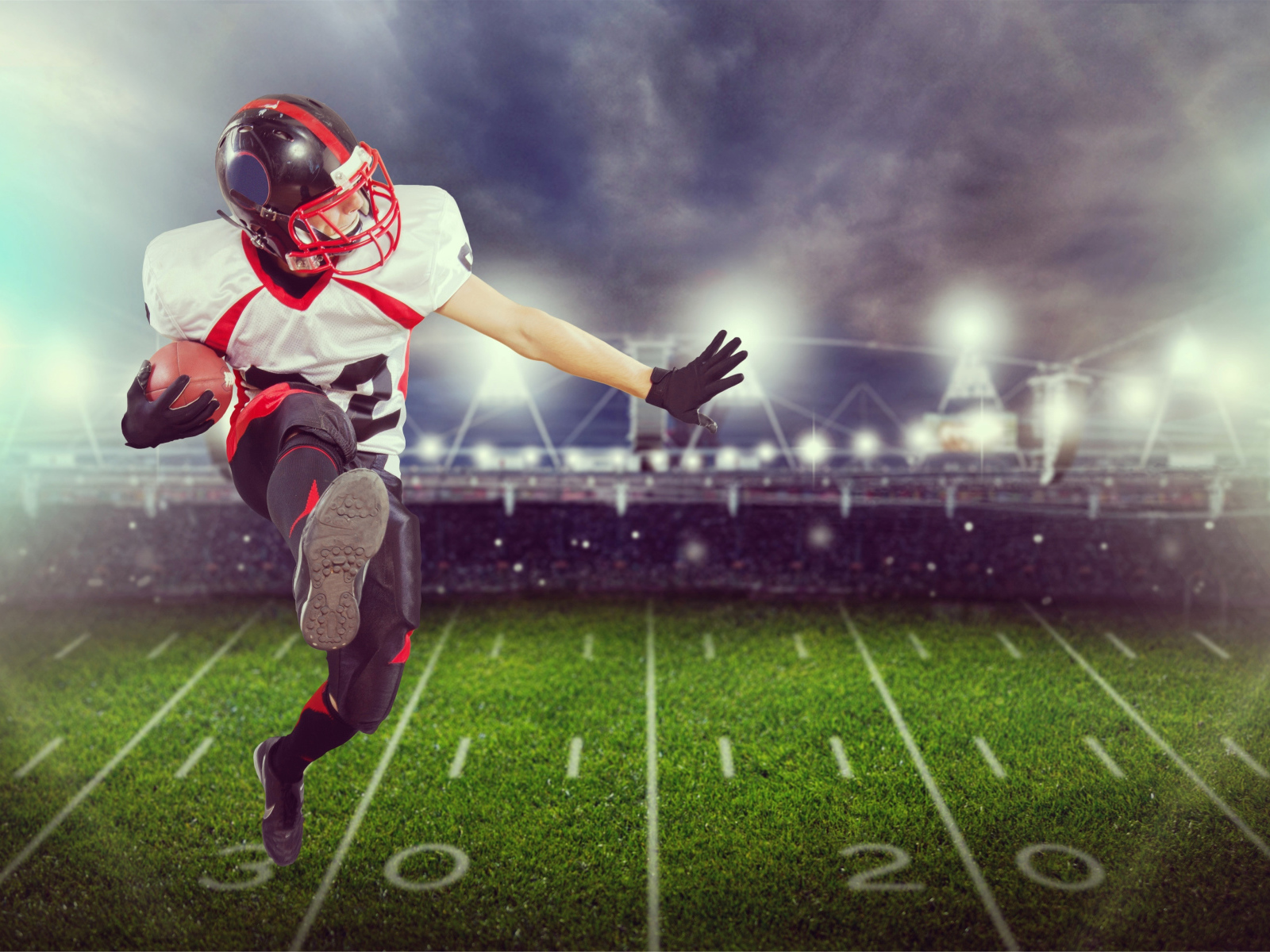 Игрок в американский футбол с мячом на поле